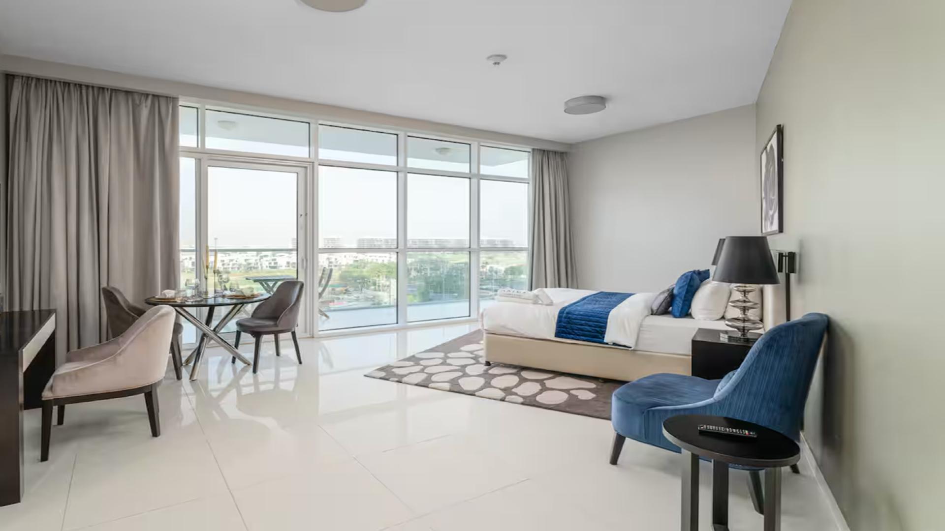 Luxurious bedroom in Artesia apartment, Damac Hills, featuring modern decor and large windows