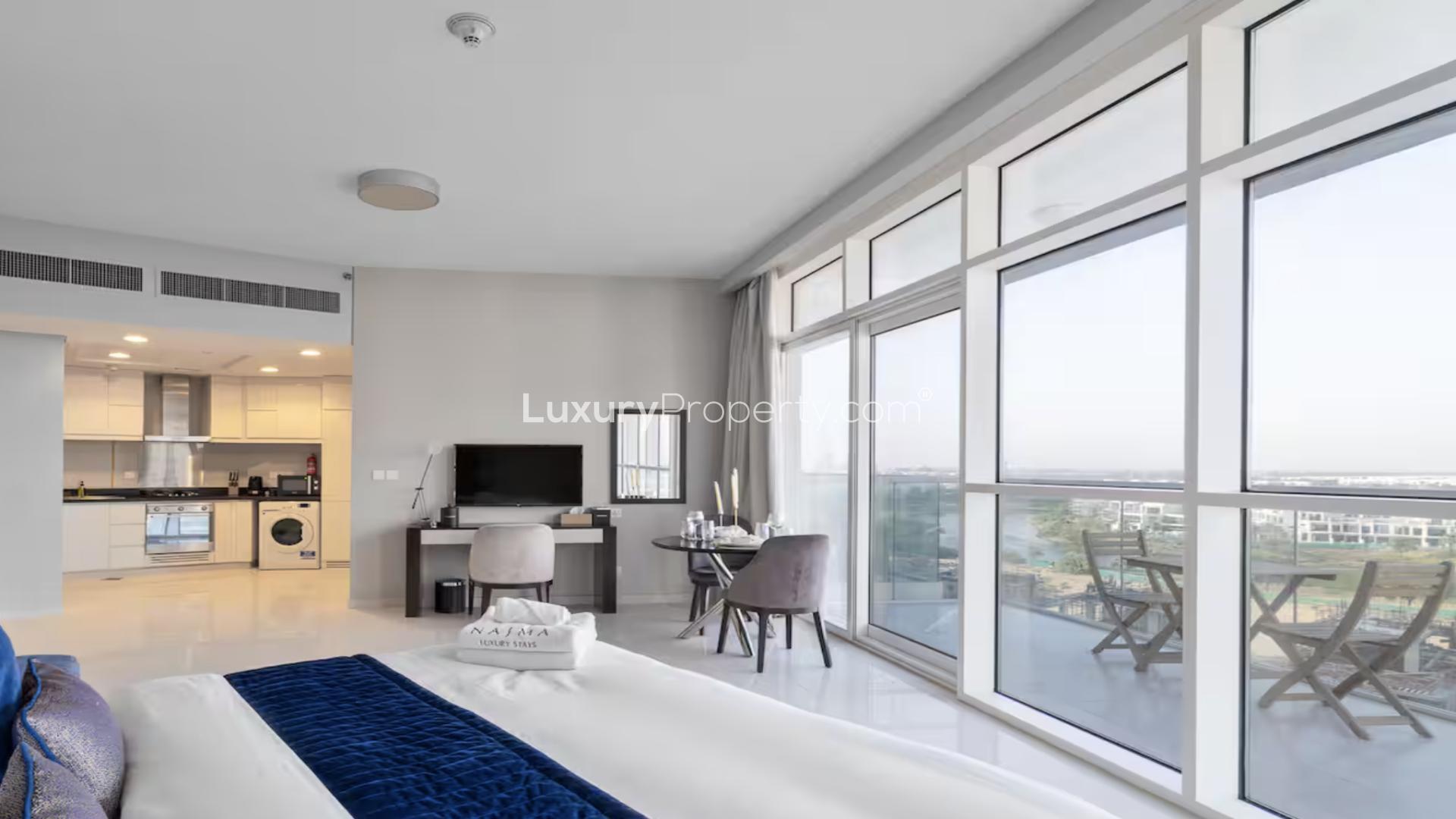 Modern furnished apartment bedroom with large windows in Artesia, Damac Hills, for sale
