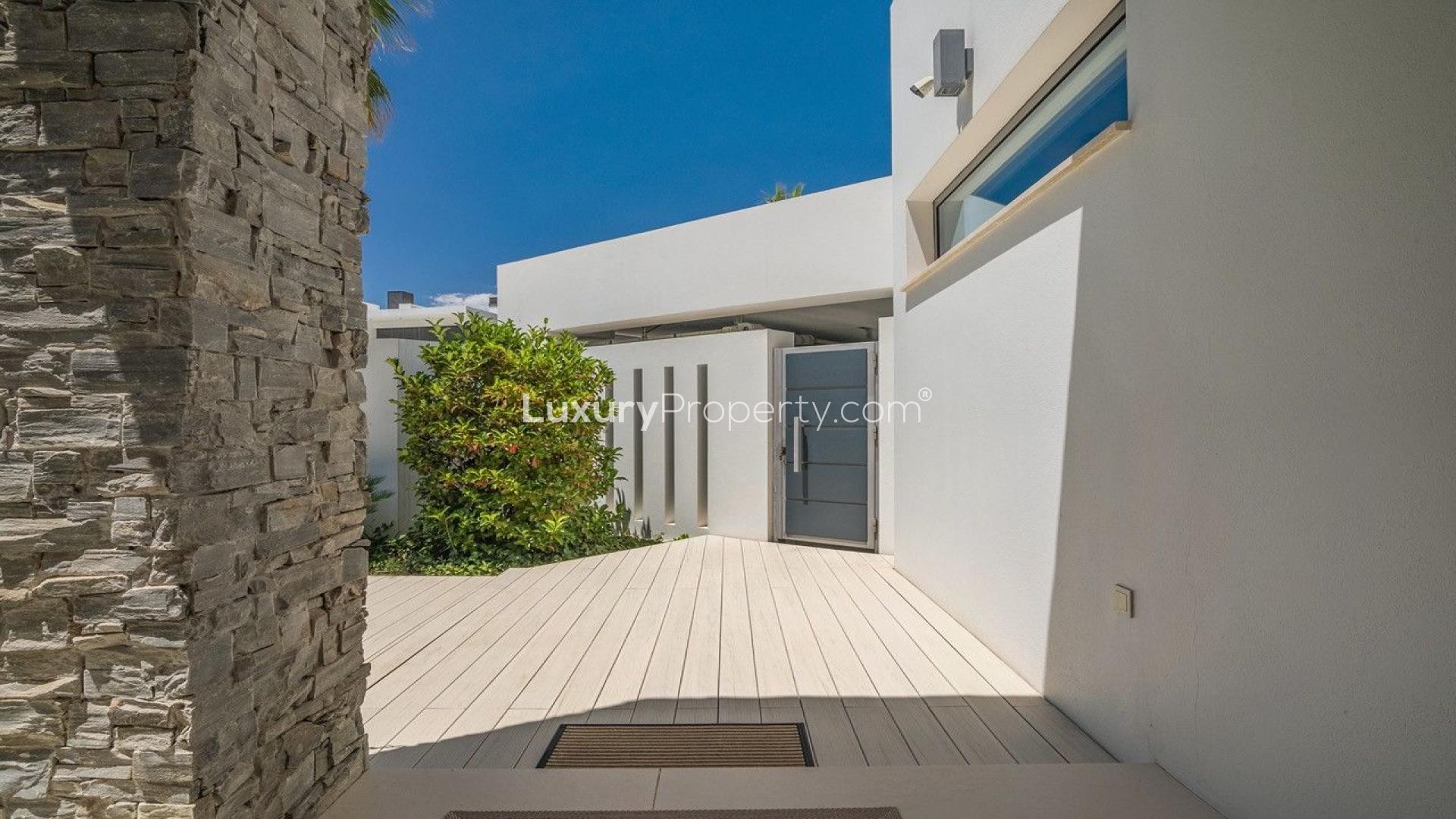 "Las Lomas de Marbella villa lush entrance garden with palm trees, The Golden Mile.",Modern entrance of Las Lomas de Marbella villa on The Golden Mile, Málaga