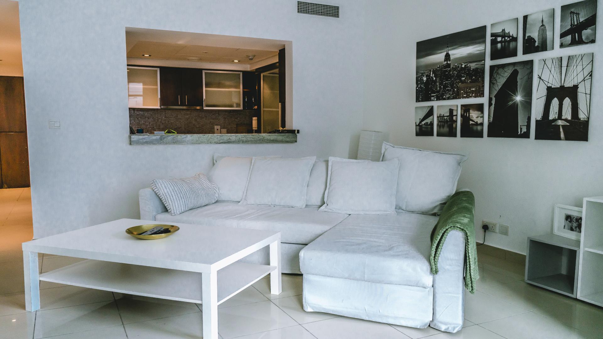 Modern living room in Dubai Marina apartment, Park Island, with marina view through large windows