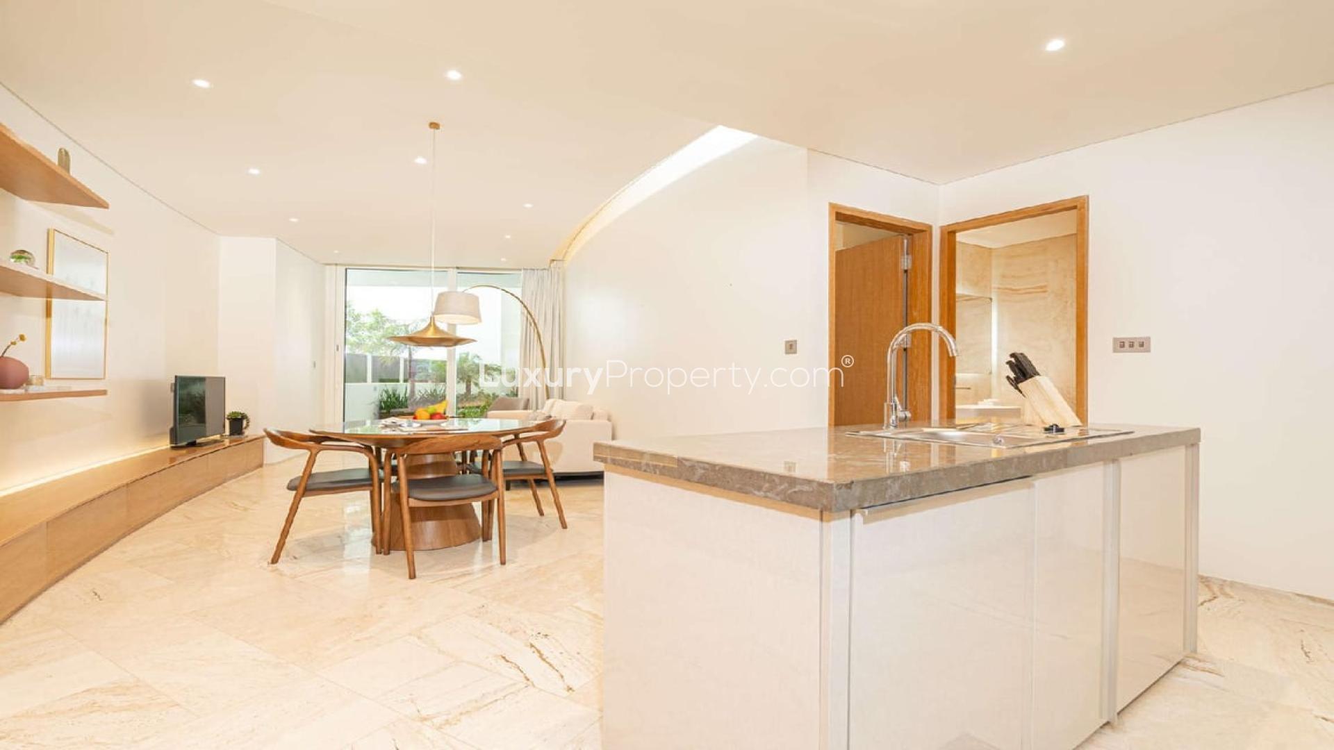 Modern living room in Jumeirah Village Circle apartment with balcony access and stylish decor