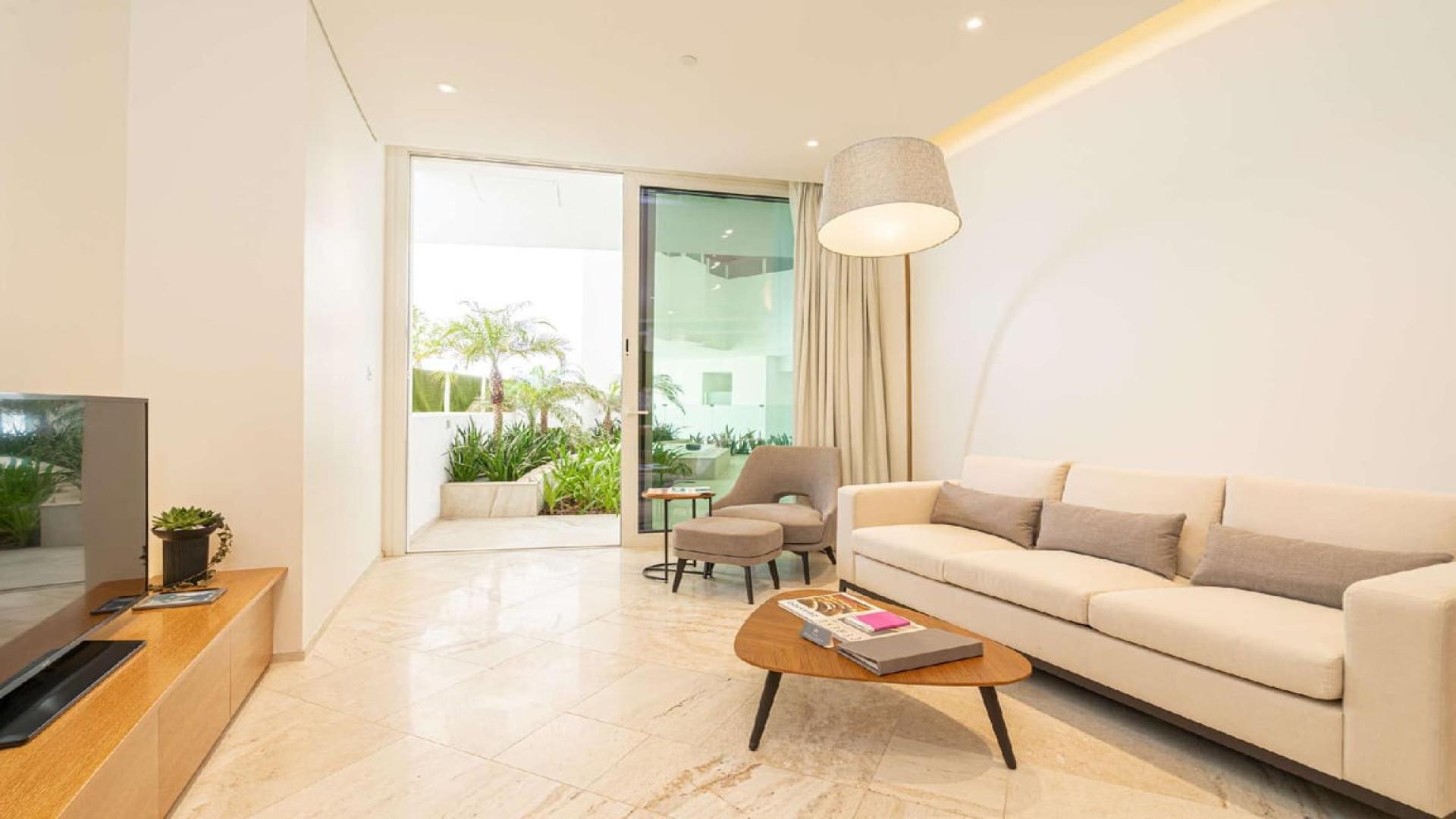 Outdoor jacuzzi surrounded by lush greenery in Jumeirah Village Circle apartment for sale