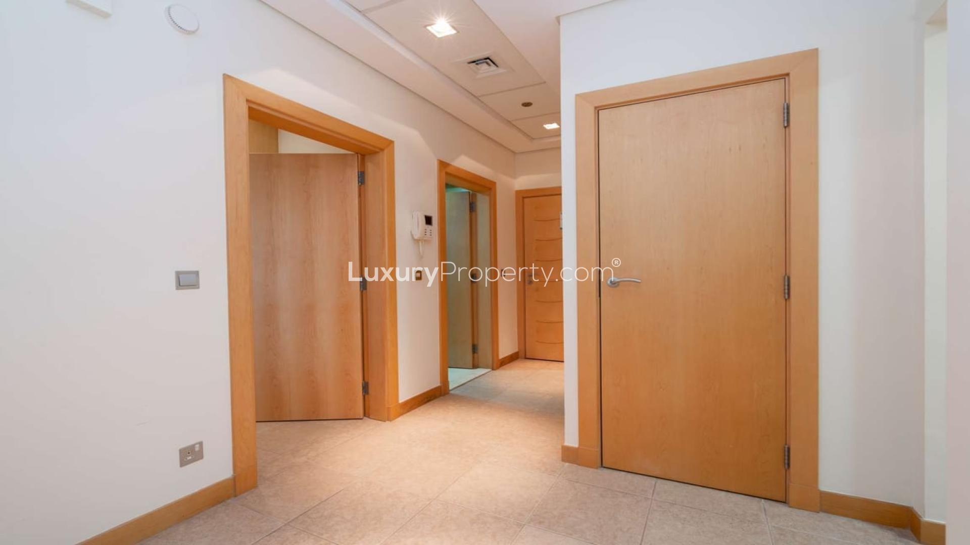 Fully furnished living room in Palm Jumeirah apartment with large window and TV setup