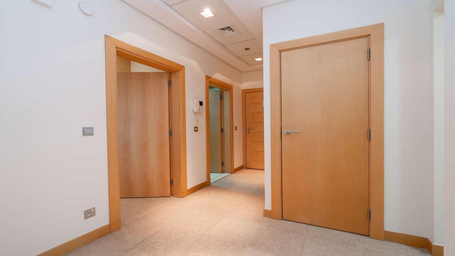 Fully furnished living room in Palm Jumeirah apartment with large window and TV setup