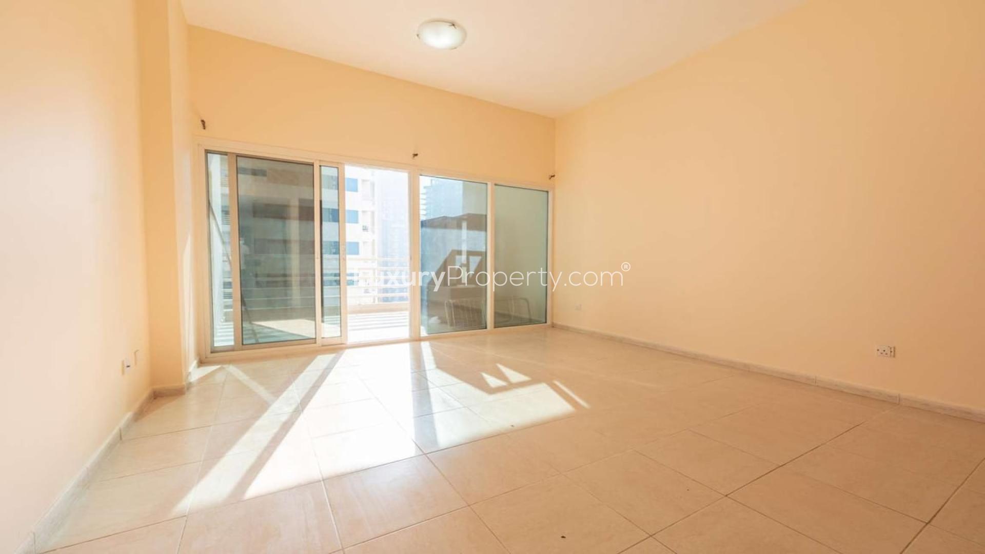 Spacious living room in renovated Dubai Sports City apartment, Olympic Park Towers, for rent