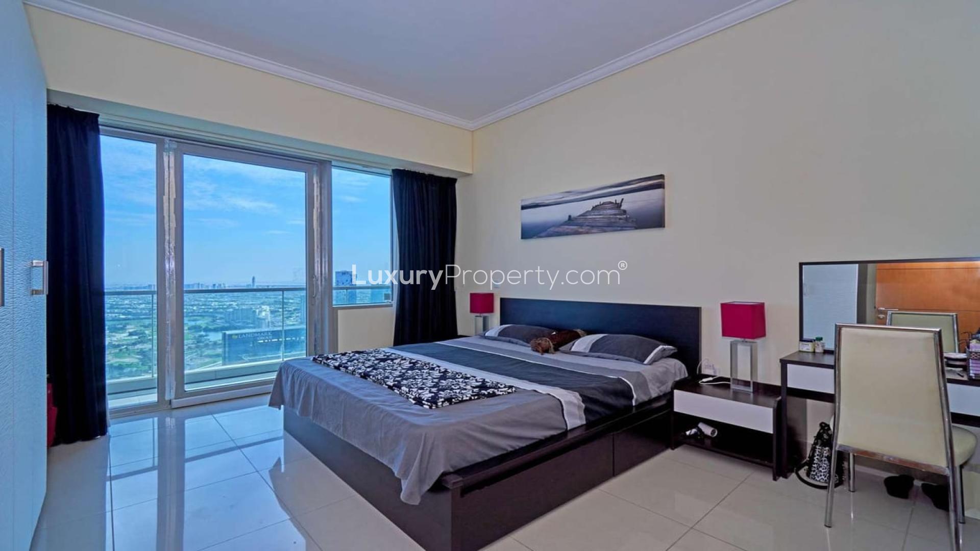 "Ocean Heights building exterior in Dubai Marina, showcasing modern architecture and high-rise design.",Fully furnished bedroom with balcony view in Ocean Heights apartment, Dubai Marina