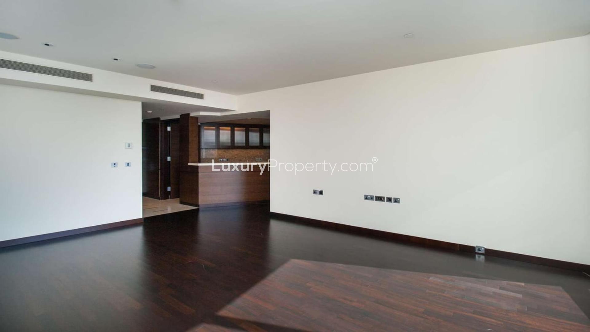 Empty living room with wooden floors, large windows, city view in Burj Khalifa apartment