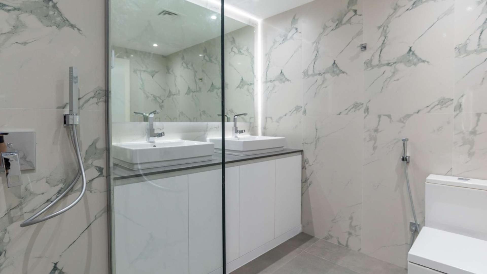 Modern kitchen in one-bedroom Shoreline apartment, Palm Jumeirah, with sleek white cabinetry