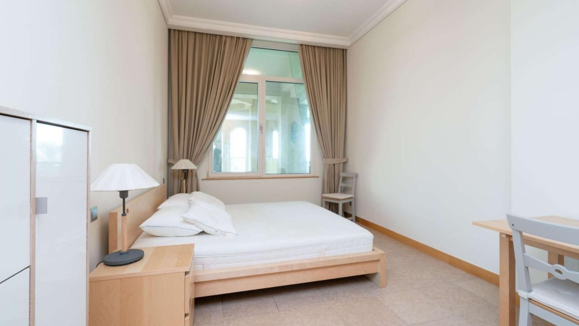 "Shoreline Apartments exterior, Palm Jumeirah, affordable 1-bedroom rental with private beach access.",One-bedroom apartment interior in Shoreline Apartments, Palm Jumeirah, with modern furnishings