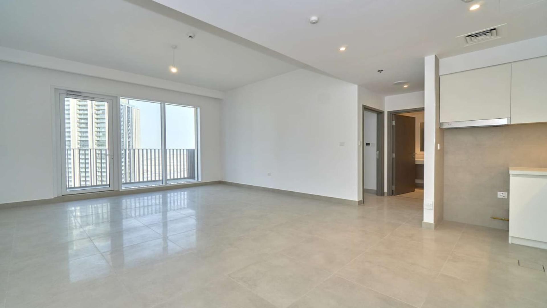 "Balcony view of modern skyscrapers from 1-bedroom apartment in Dubai Creek Harbour.",Brand new 1-bedroom apartment interior with large windows in Dubai Creek Harbour