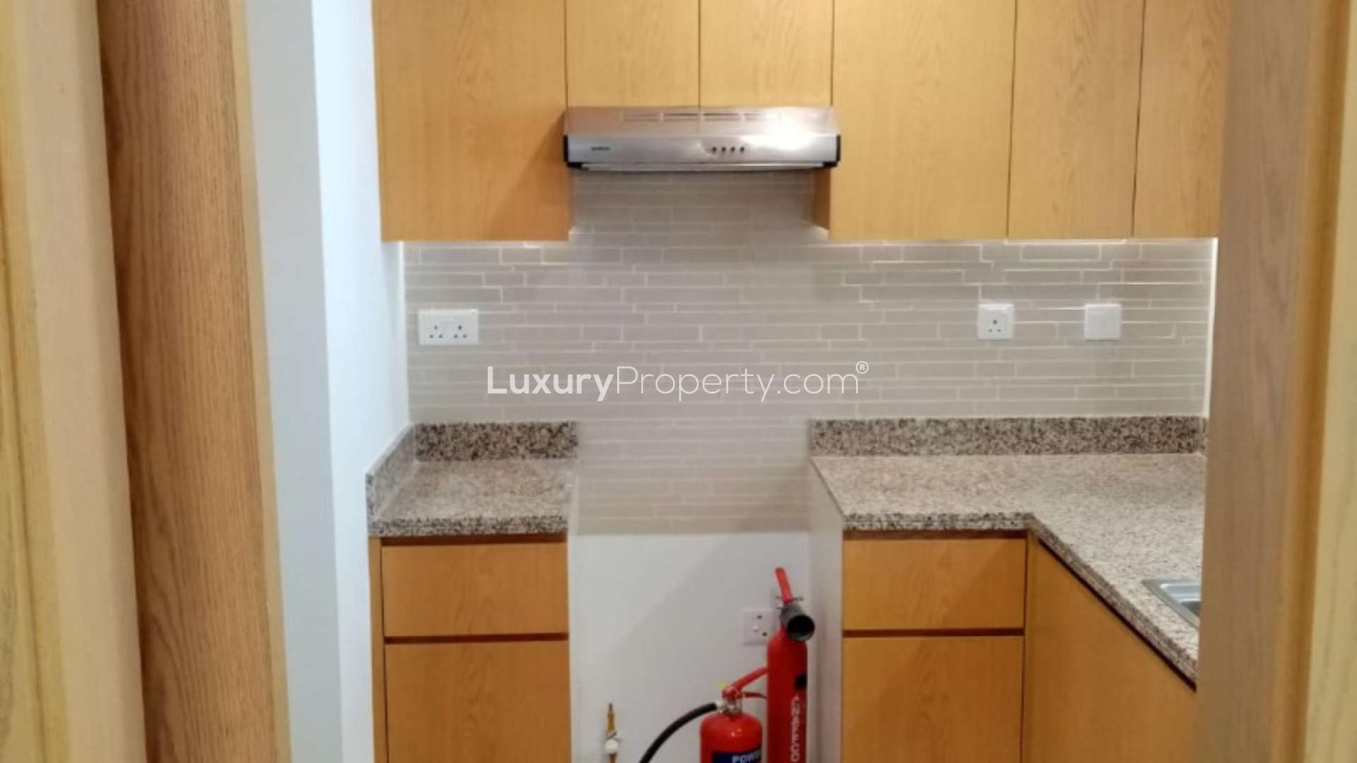 "Spacious living area in Bellevue Towers apartment, Downtown Dubai, with modern open kitchen design.",Modern kitchen in Bellevue Towers apartment, Downtown Dubai, with wooden cabinets and granite countertops