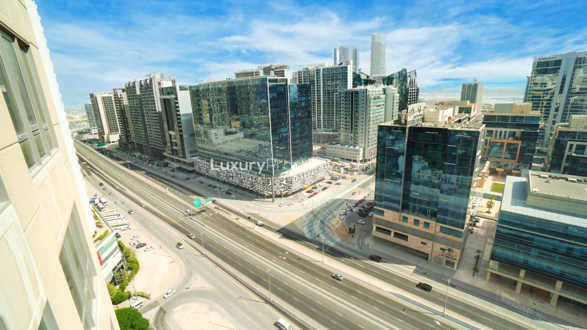 Balcony view from South Ridge apartment overlooking Downtown Dubai skyline, wooden seating area