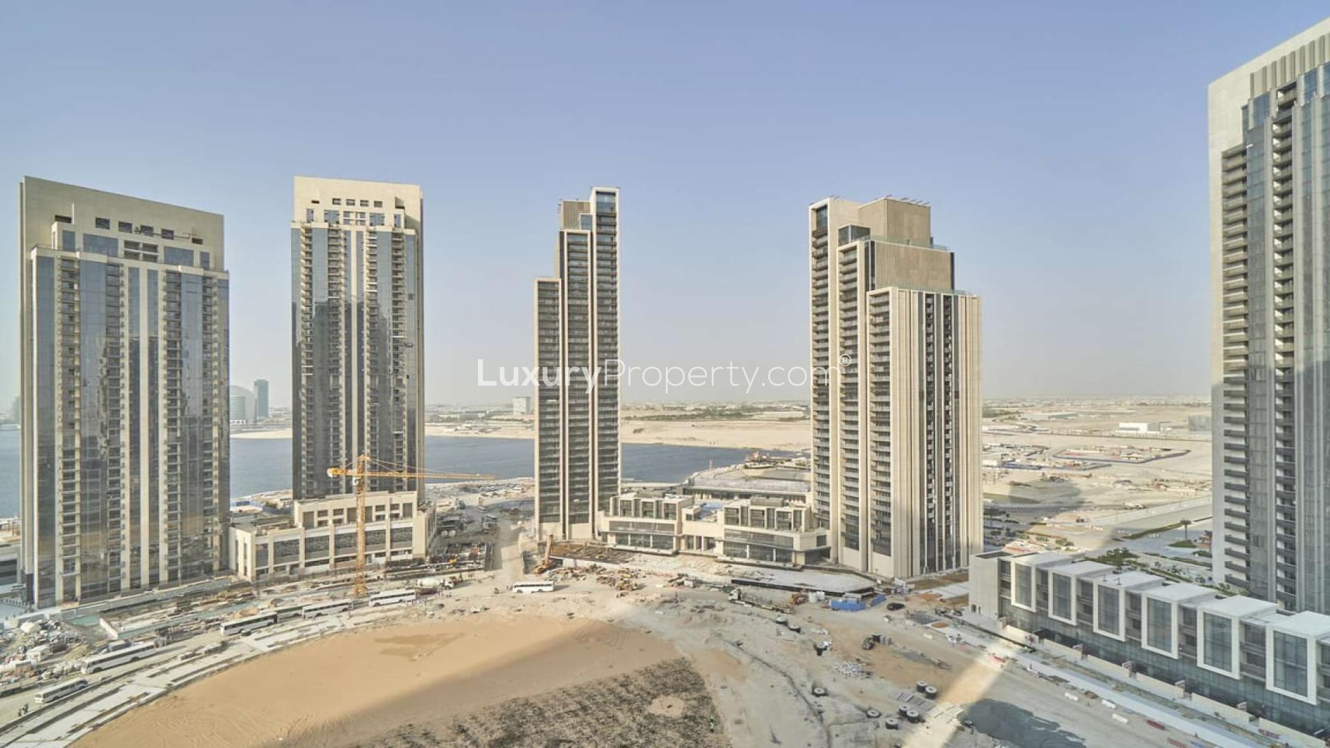 Empty living room in Creek Horizon apartment, large windows with city view, Dubai Creek Harbour