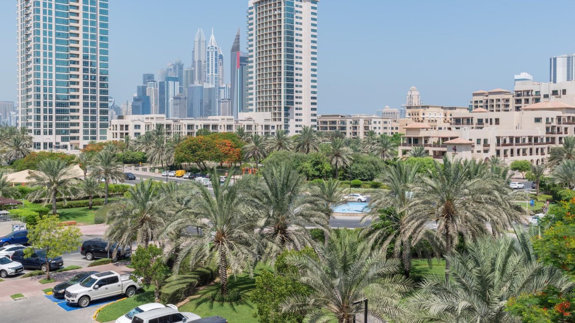 Fully-furnished living room in 1-bedroom apartment, The Greens, Al Dhafra, with park views