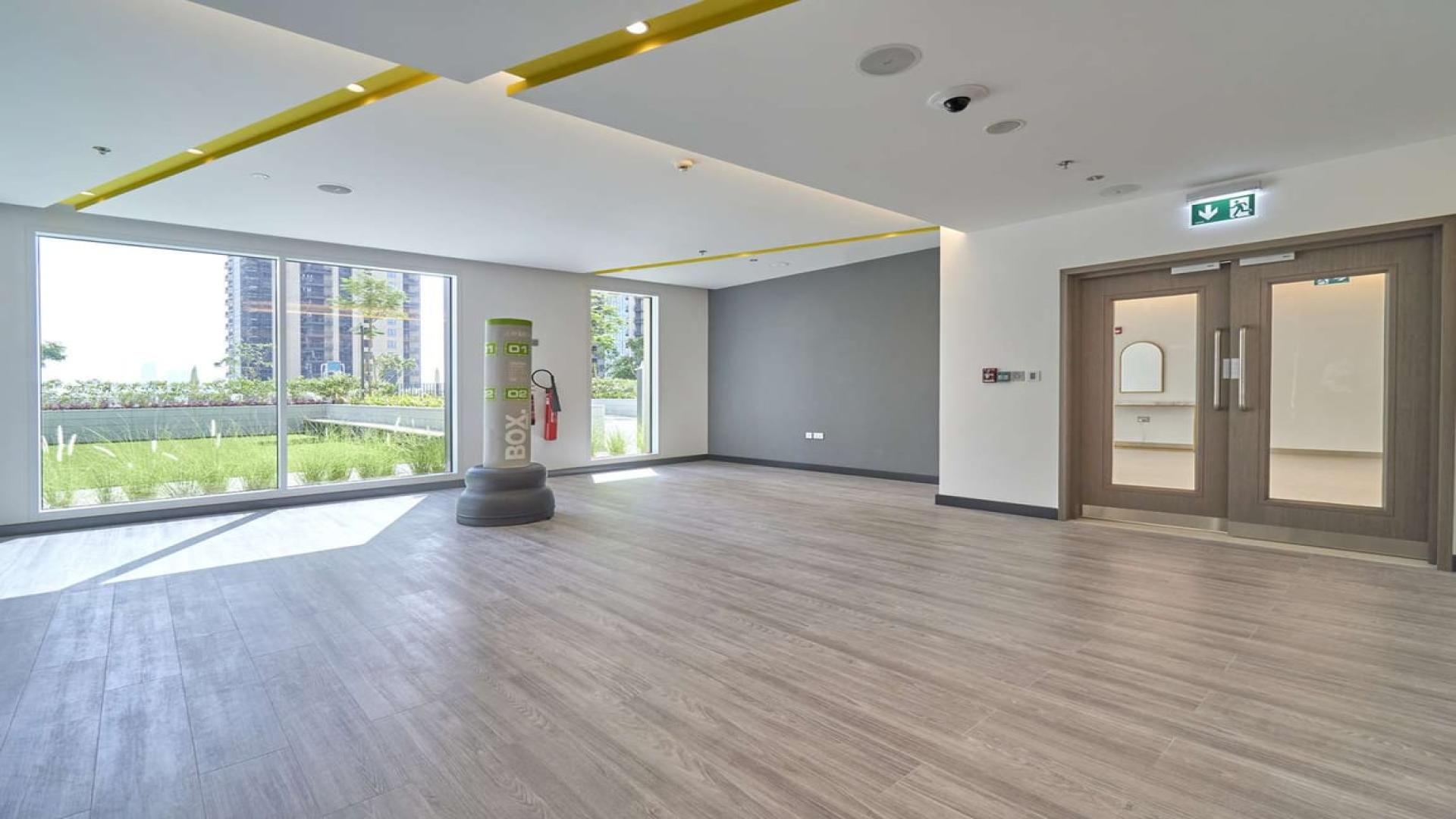 Modern open space in Dubai Creek Harbour apartment, featuring large windows and wooden flooring