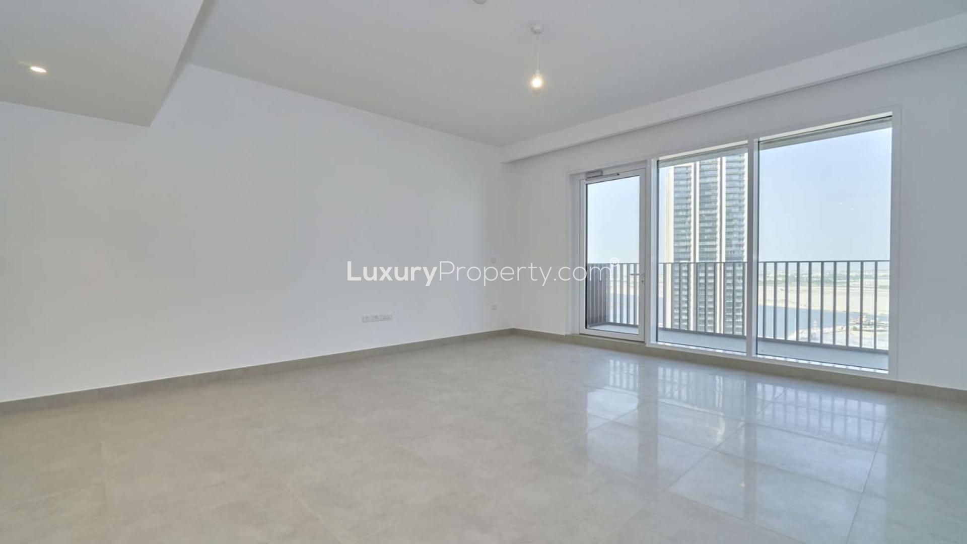Empty living room with large windows and park views in Dubai Creek Harbour apartment