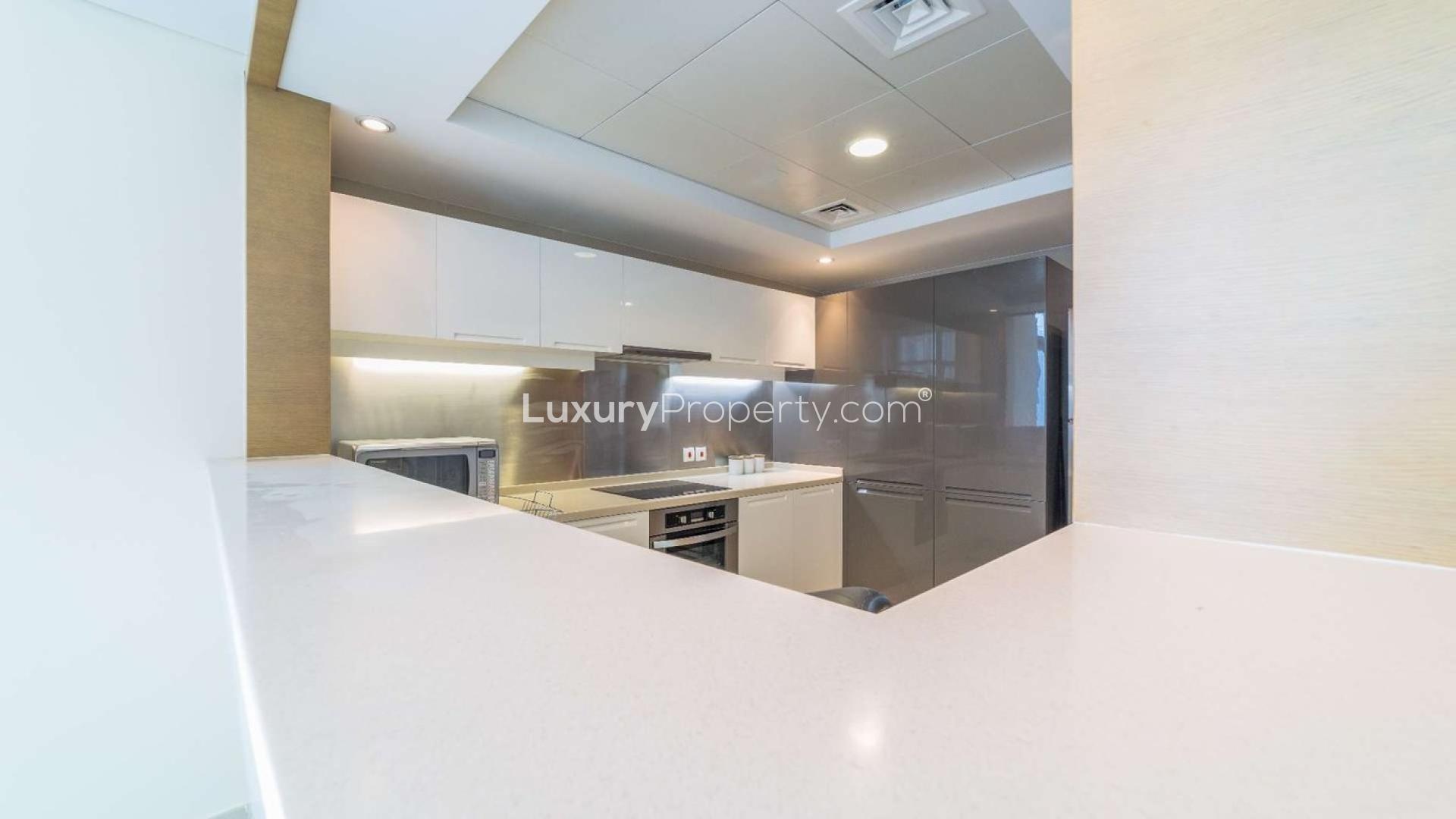 Modern living room in Downtown Dubai apartment, Claren Towers, with fitted kitchen and balcony view