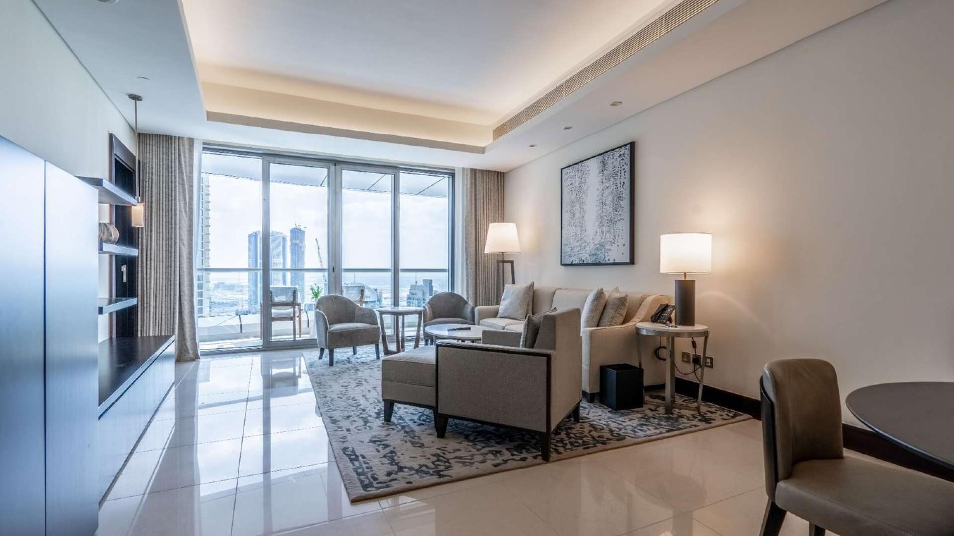 Luxurious downtown Dubai apartment living room with modern furnishings and city view balcony