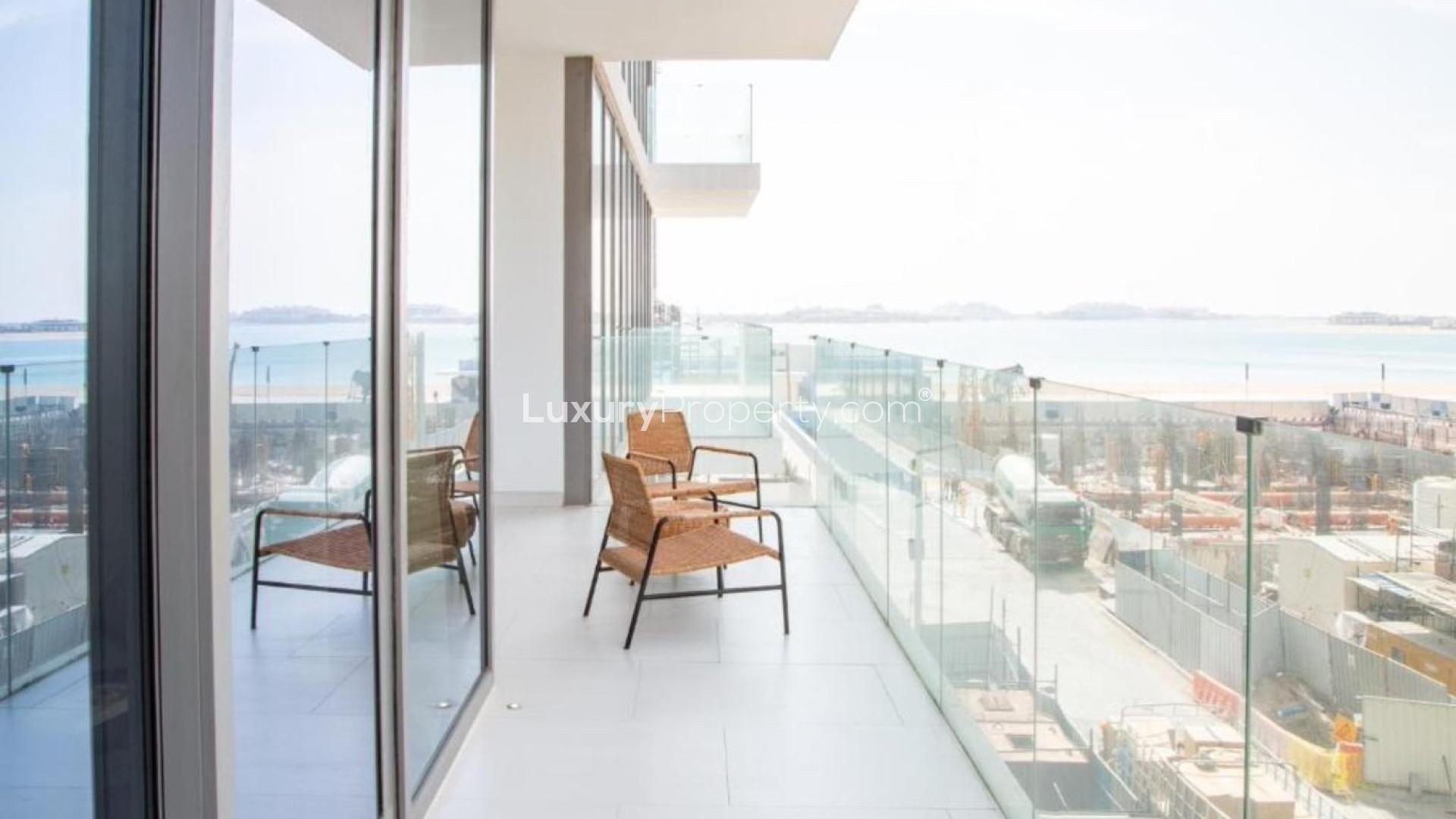 Modern kitchen in Palm Jumeirah apartment, featuring sleek white cabinets and island stove