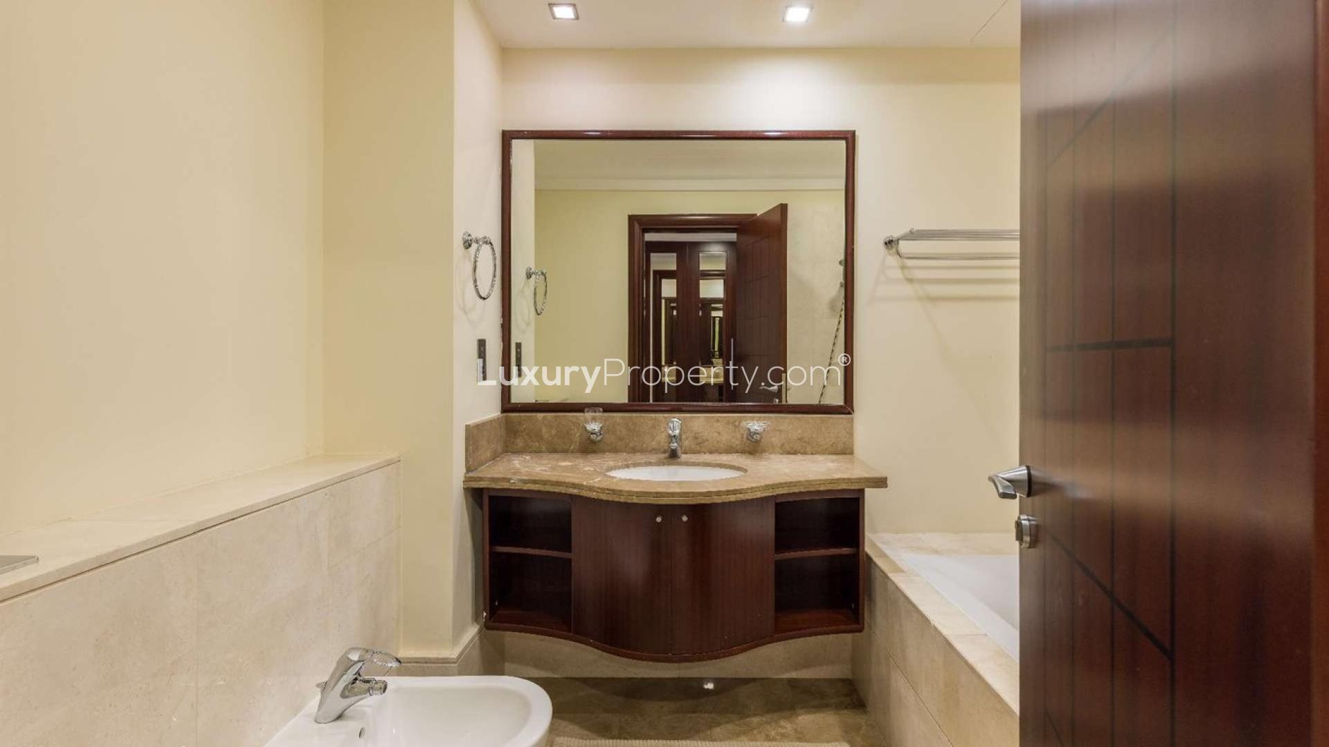 Luxurious bathroom in one-bedroom Palm Jumeirah apartment, featuring elegant marble countertop and fixtures