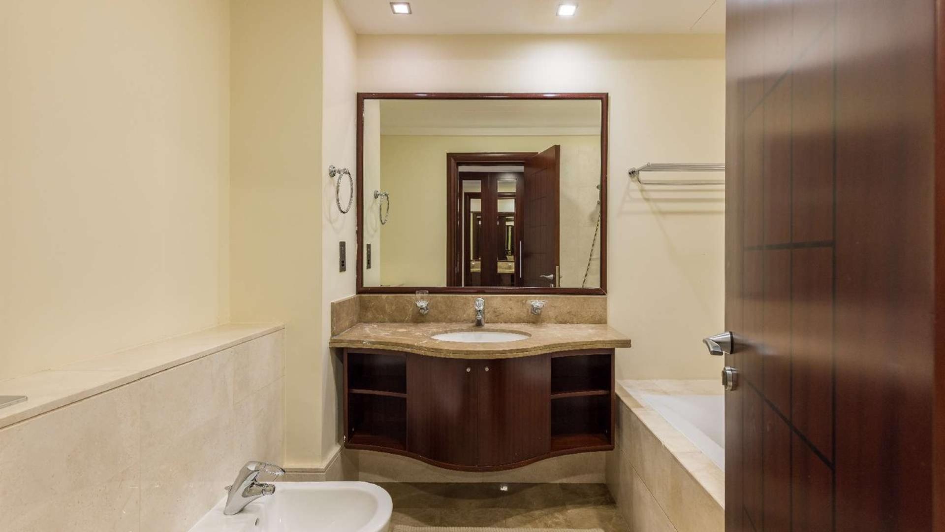 Luxurious bathroom in one-bedroom Palm Jumeirah apartment, featuring elegant marble countertop and fixtures