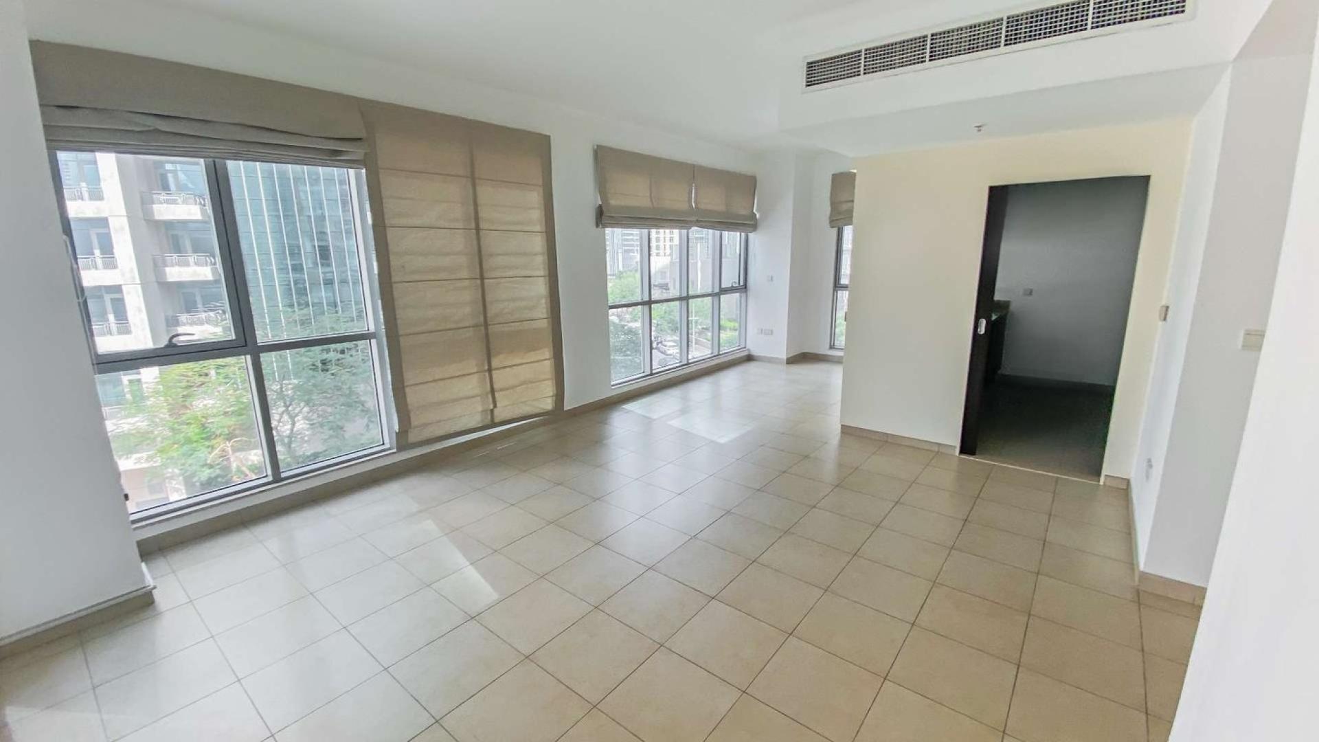 Modern kitchen in 1-bedroom Downtown Dubai apartment, featuring dark cabinets and granite countertops