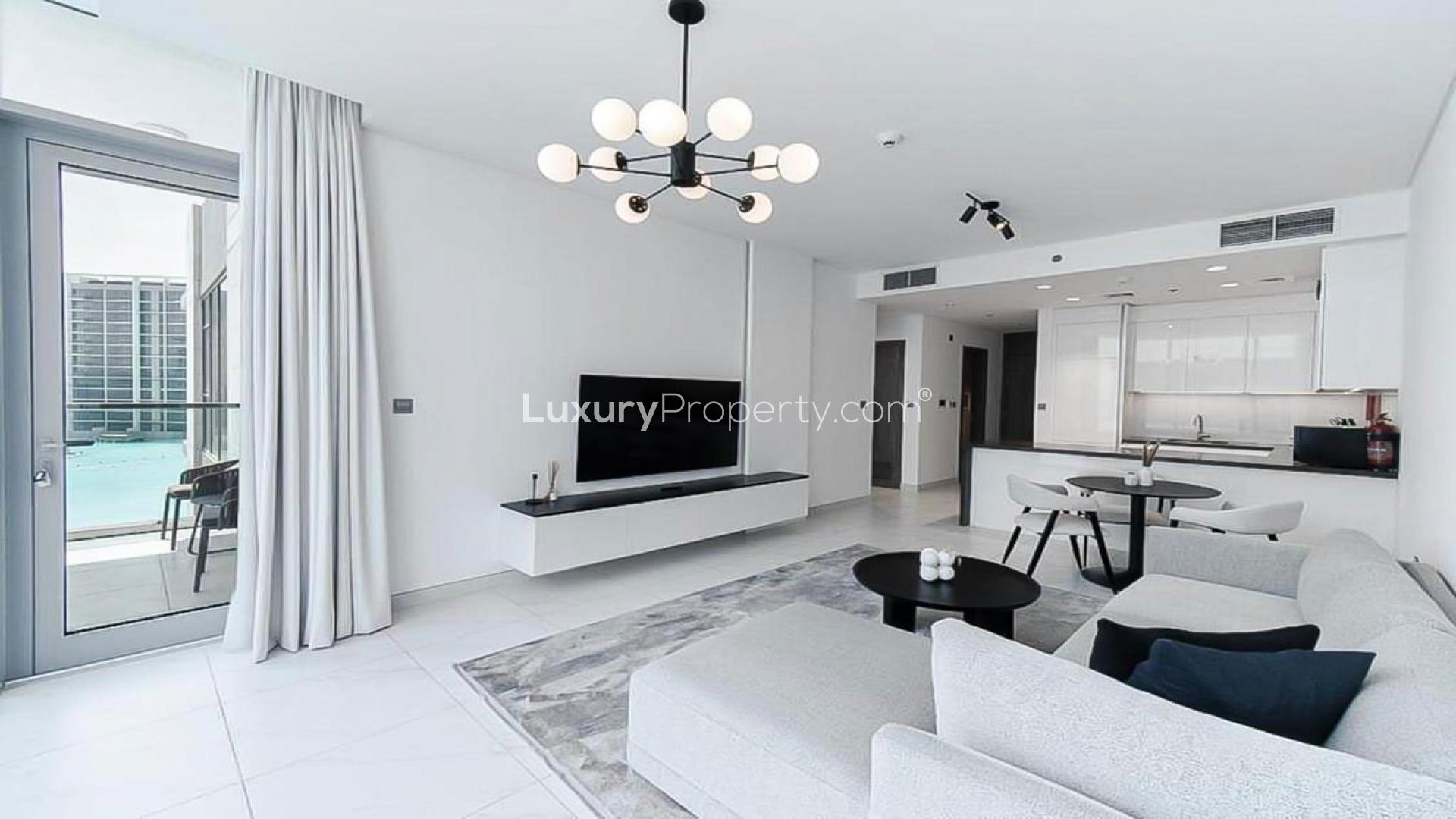 "Balcony view of lagoon and modern buildings, District One apartment, Mohammed Bin Rashid City.",Modern living room in lagoon-view apartment, District One, Mohammed Bin Rashid City