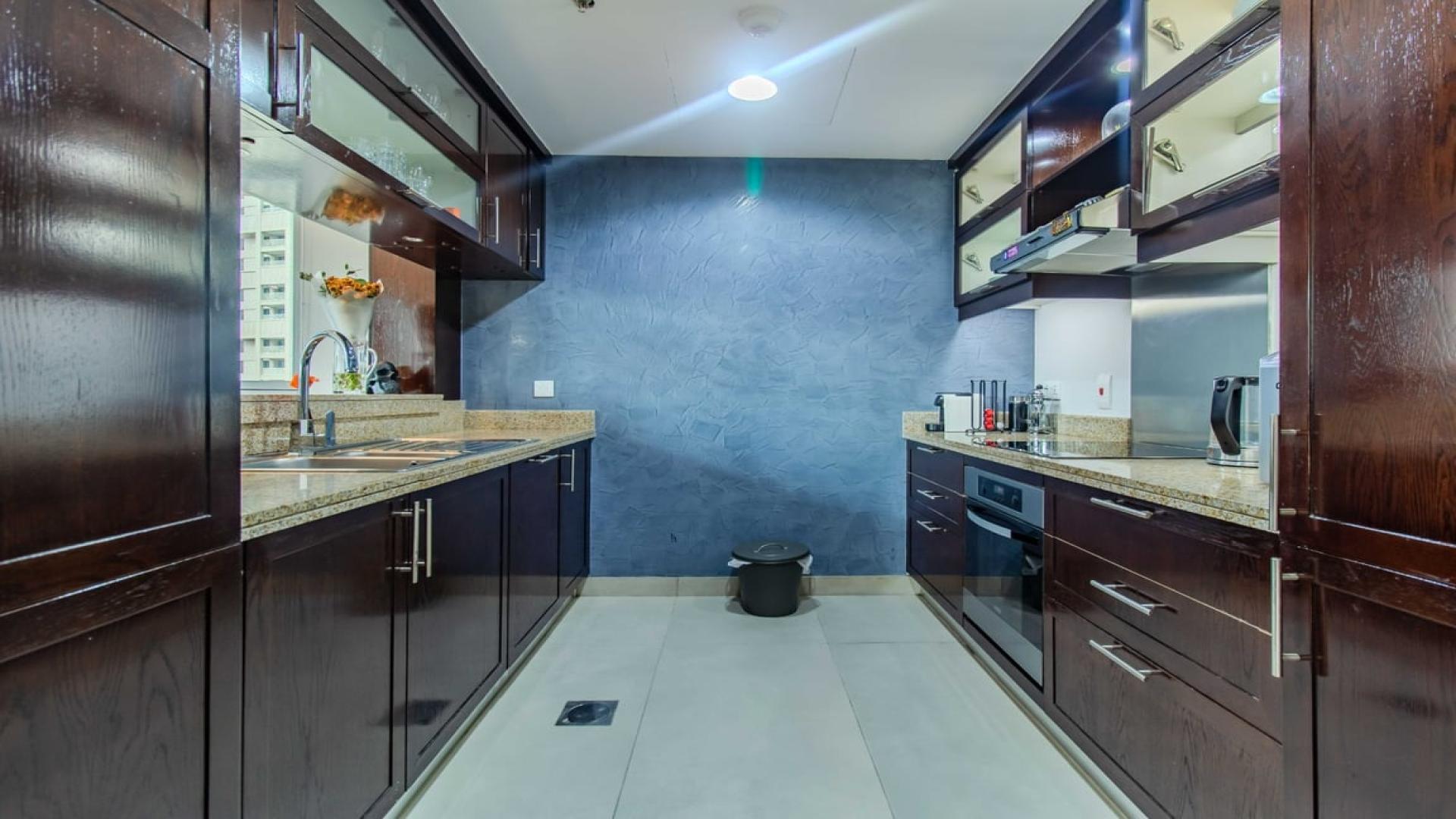 Furnished kitchen in 1-bedroom apartment, The Residences, Downtown Dubai, featuring modern dark wood cabinets