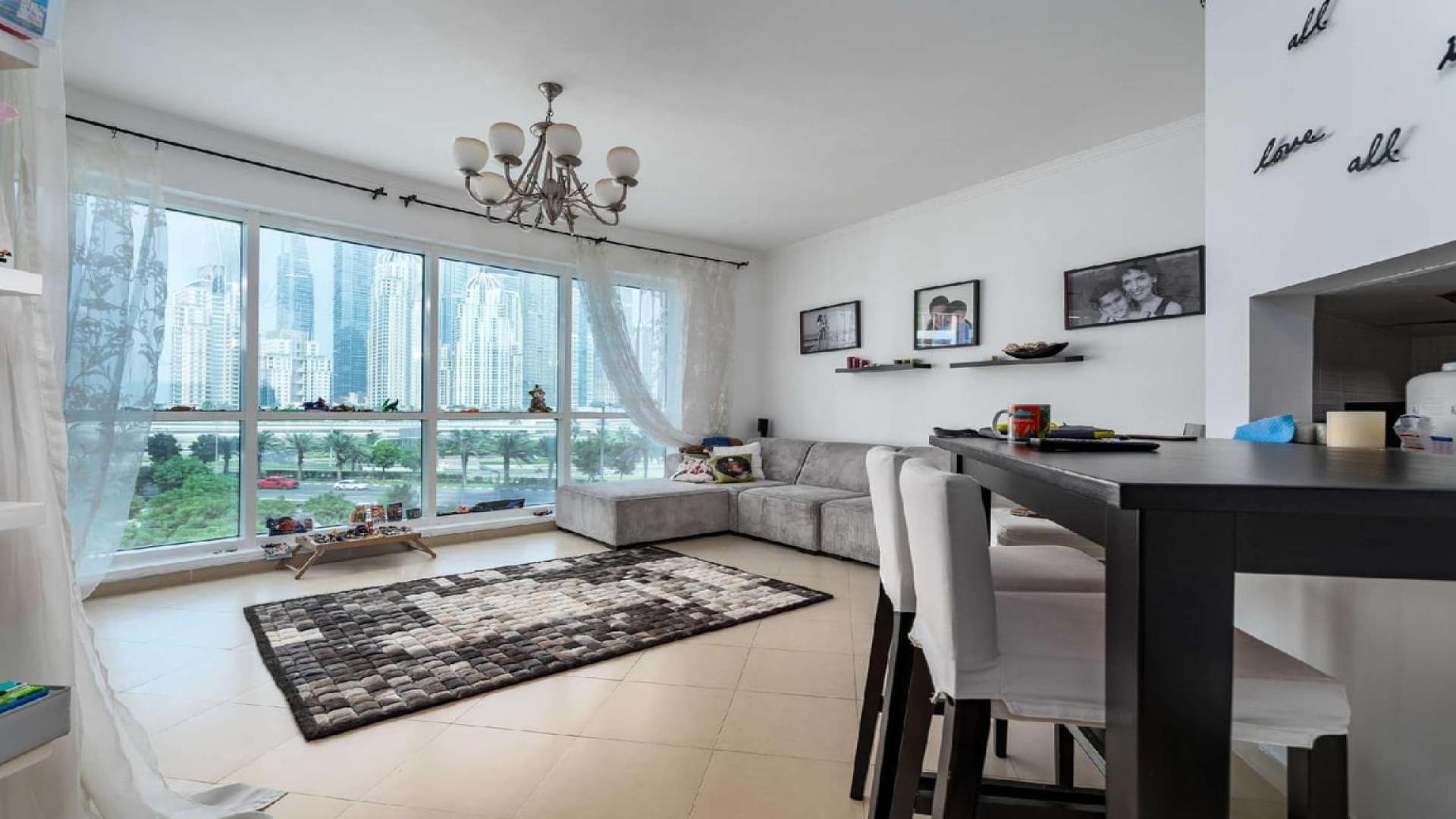 N/A,Bright living room with large windows and city view in one-bedroom apartment for sale