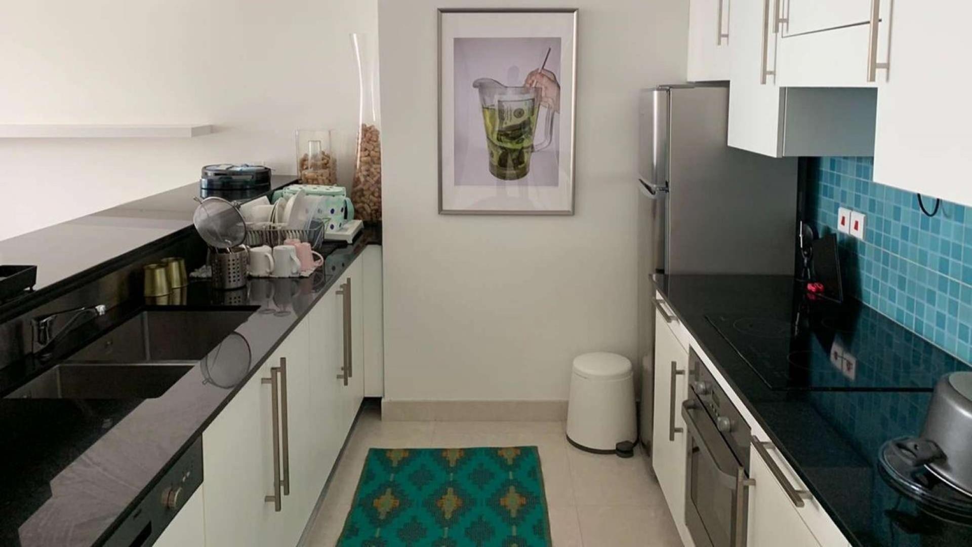 Modern kitchen in upgraded DIFC Burj Daman apartment, featuring sleek countertops and appliances