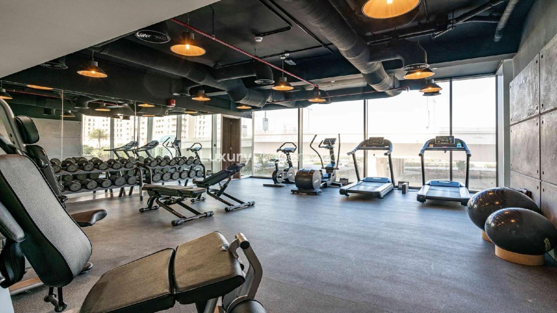 Modern open-plan kitchen and dining area in Soho Palm Jumeirah apartment for sale