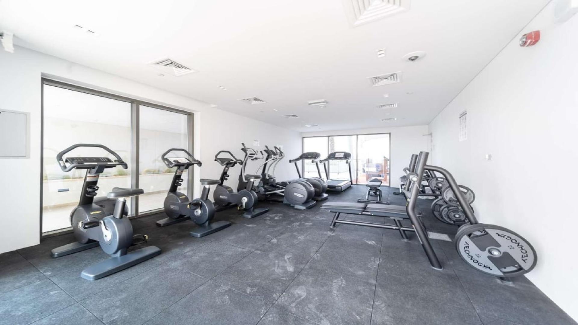 Empty living room with kitchen entrance in Mudon Views apartment for sale