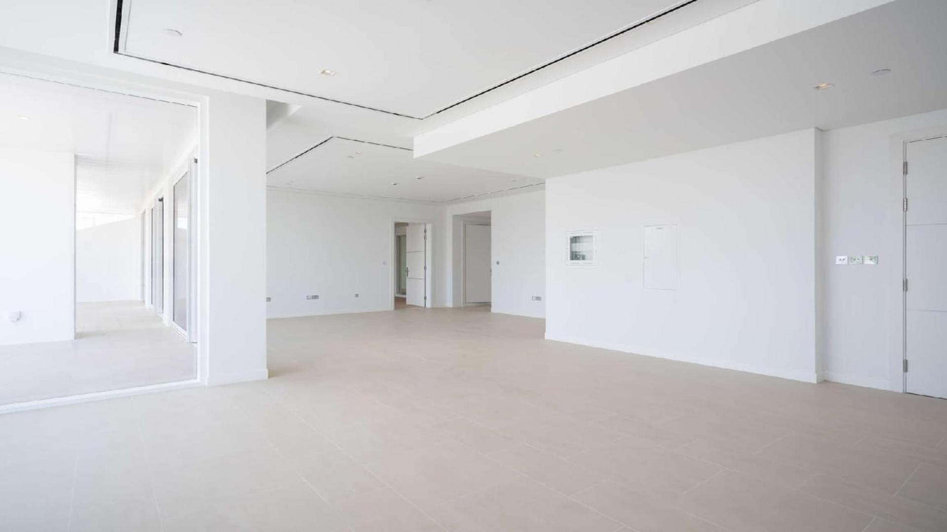 Modern kitchen and living area in Al Barari's Seventh Heaven apartment for sale