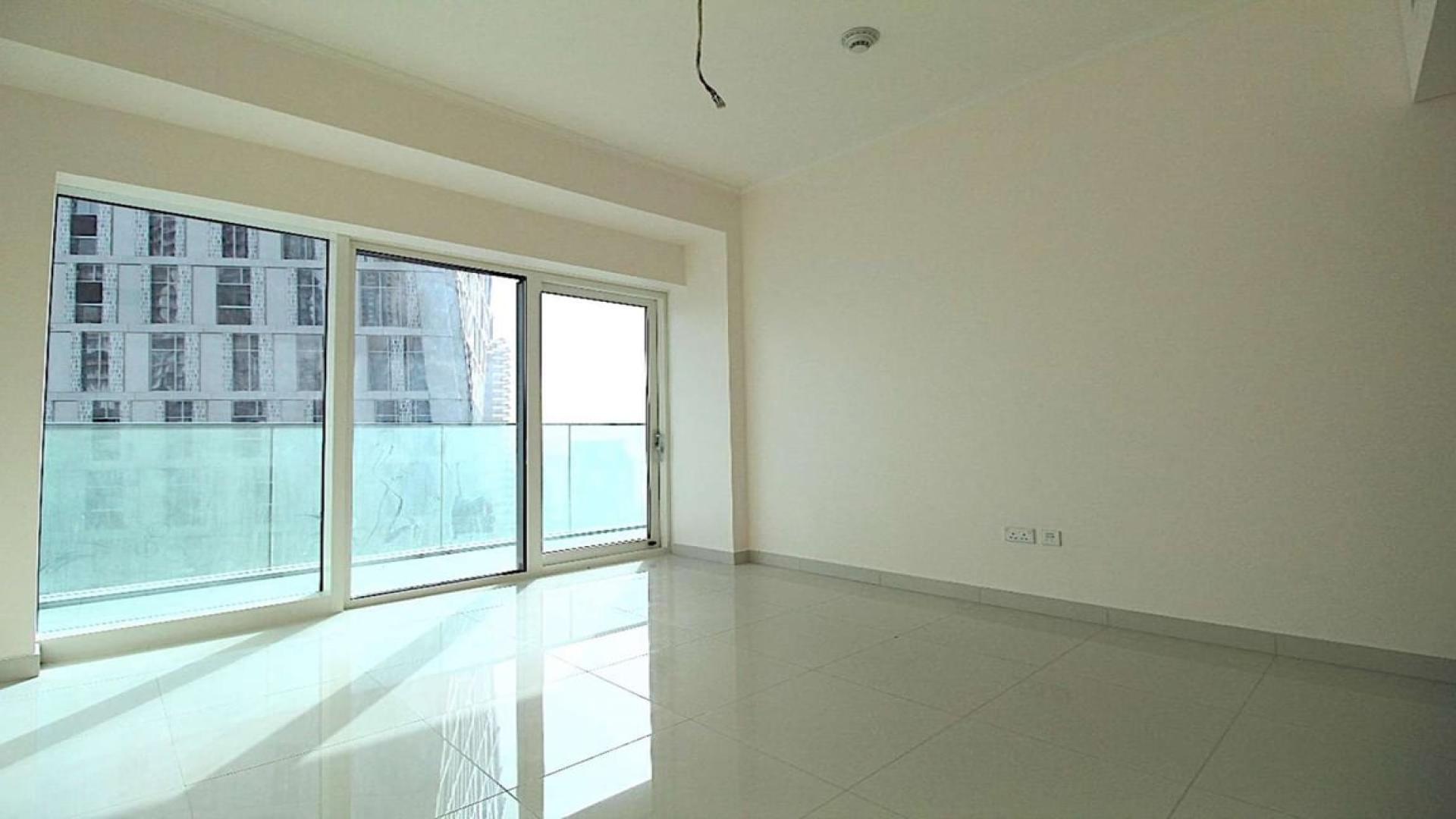 Empty living room with open kitchen in Damac Heights apartment, Dubai Marina