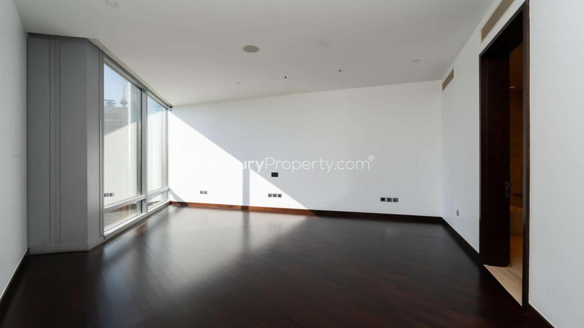 "Spacious open-plan living area in Downtown Dubai apartment with modern kitchen and city views.",Spacious living area with large windows in Burj Khalifa apartment, Downtown Dubai