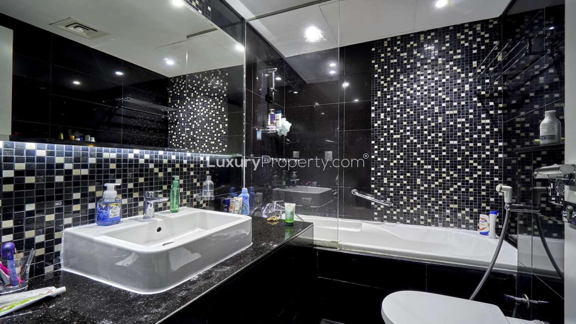 "Stunning view from The Vogue apartment overlooking Business Bay canal, Dubai skyline visible.",Modern bathroom with mosaic tiles in furnished apartment, DAMAC Maison The Vogue, Business Bay