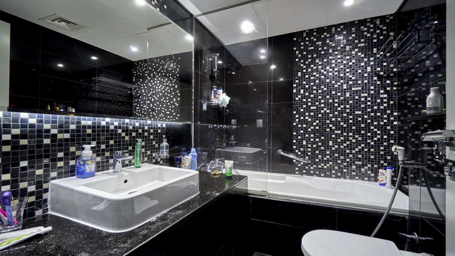 "Stunning view from The Vogue apartment overlooking Business Bay canal, Dubai skyline visible.",Modern bathroom with mosaic tiles in furnished apartment, DAMAC Maison The Vogue, Business Bay