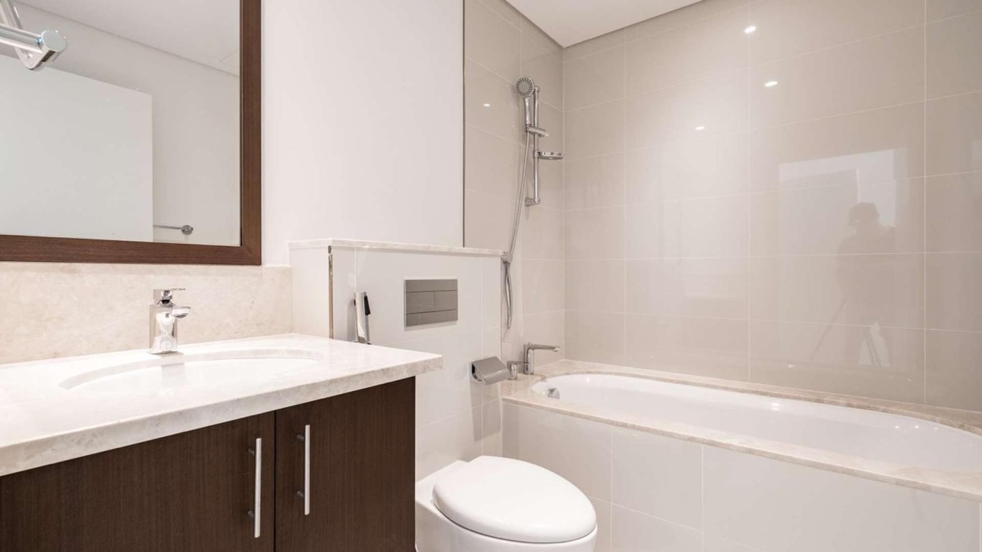 Modern bathroom in one-bedroom apartment, BLVD Crescent, Downtown Dubai, featuring sleek fixtures and bathtub