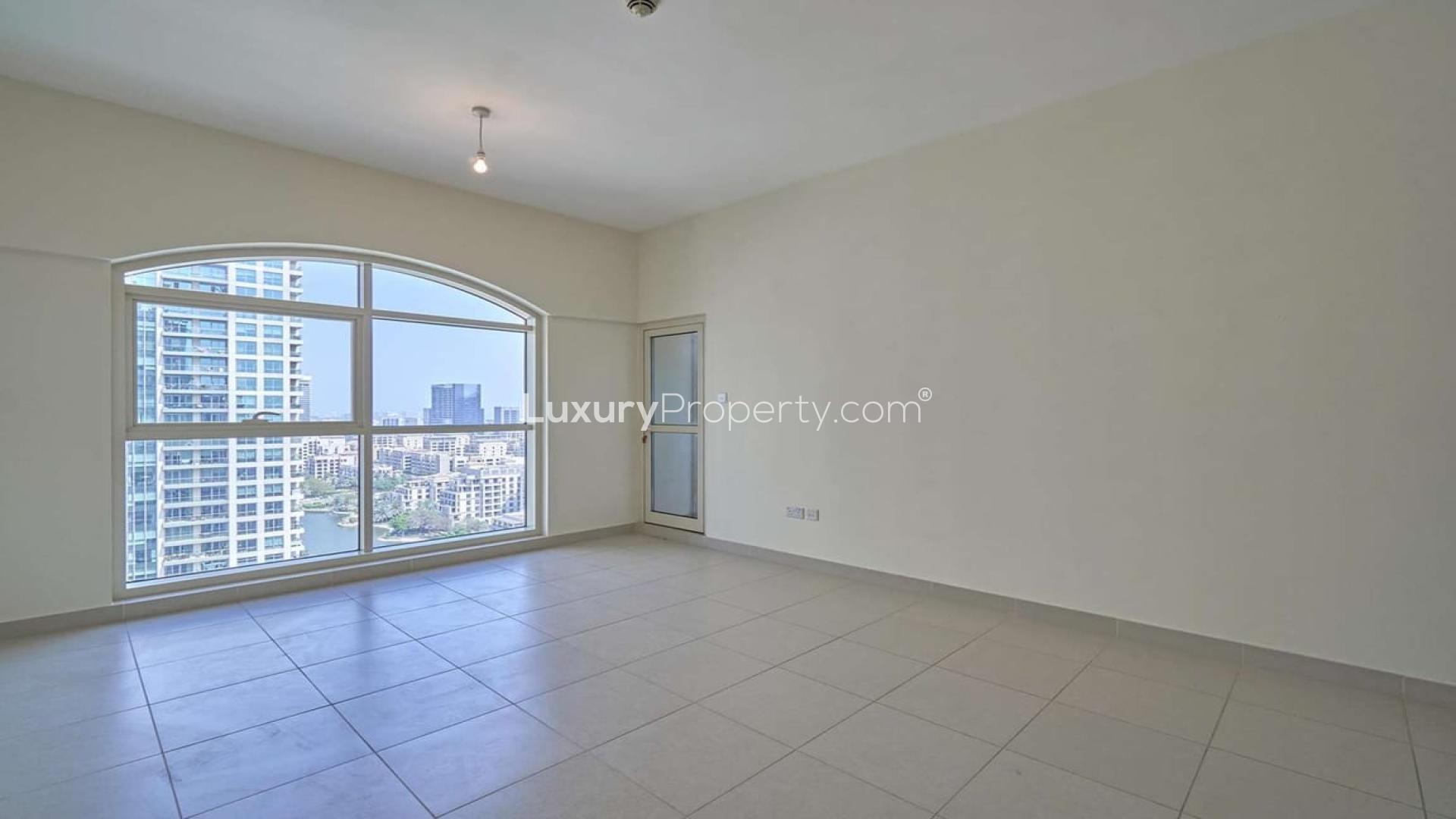 "High-rise apartment with stunning lake and city views in The Greens, Tanaro.",Empty apartment room with large window and lake view in Tanaro, The Views