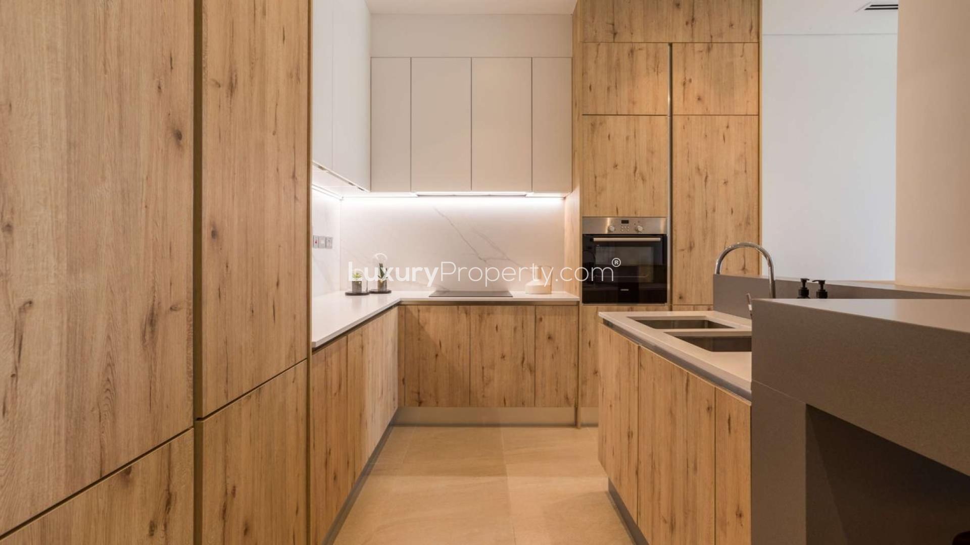 Lush garden view of Al Barari apartment for sale, featuring modern architecture and greenery