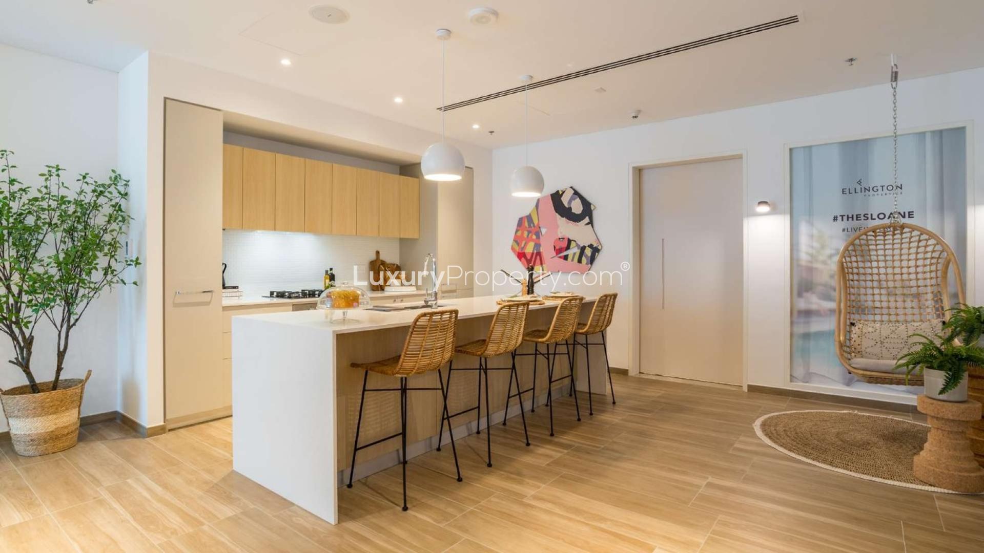 Modern kitchen in JVC apartment, featuring island seating and stylish decor at The Sloane