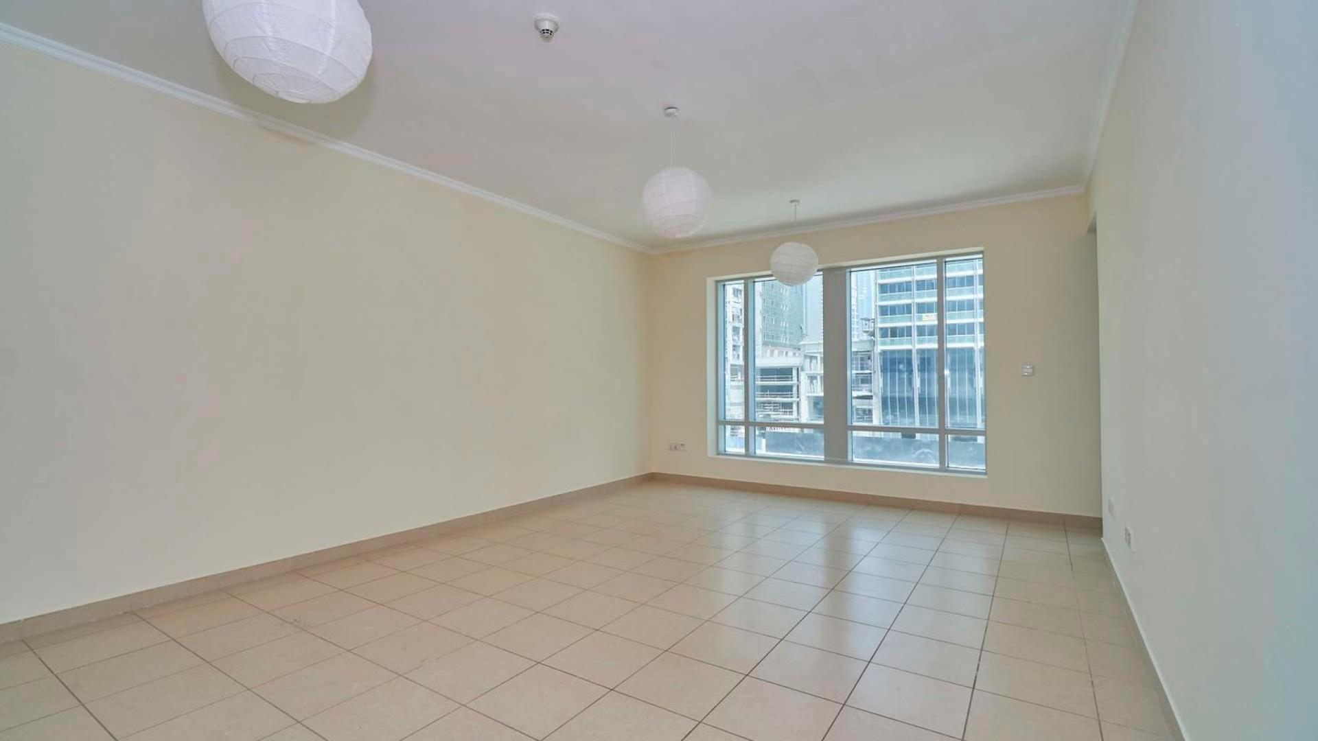 Spacious living room in one-bedroom apartment, Burj Views, Downtown Dubai. Bright windows, tiled floor