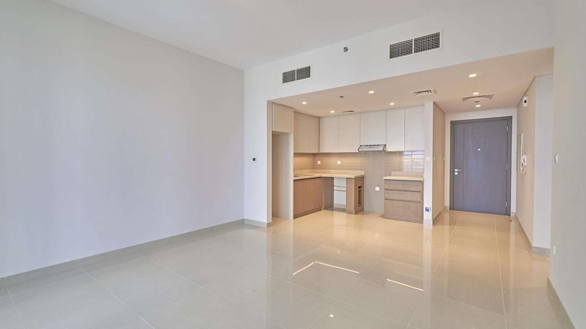 Empty modern kitchen and living area in Dubai Creek Harbour apartment for sale