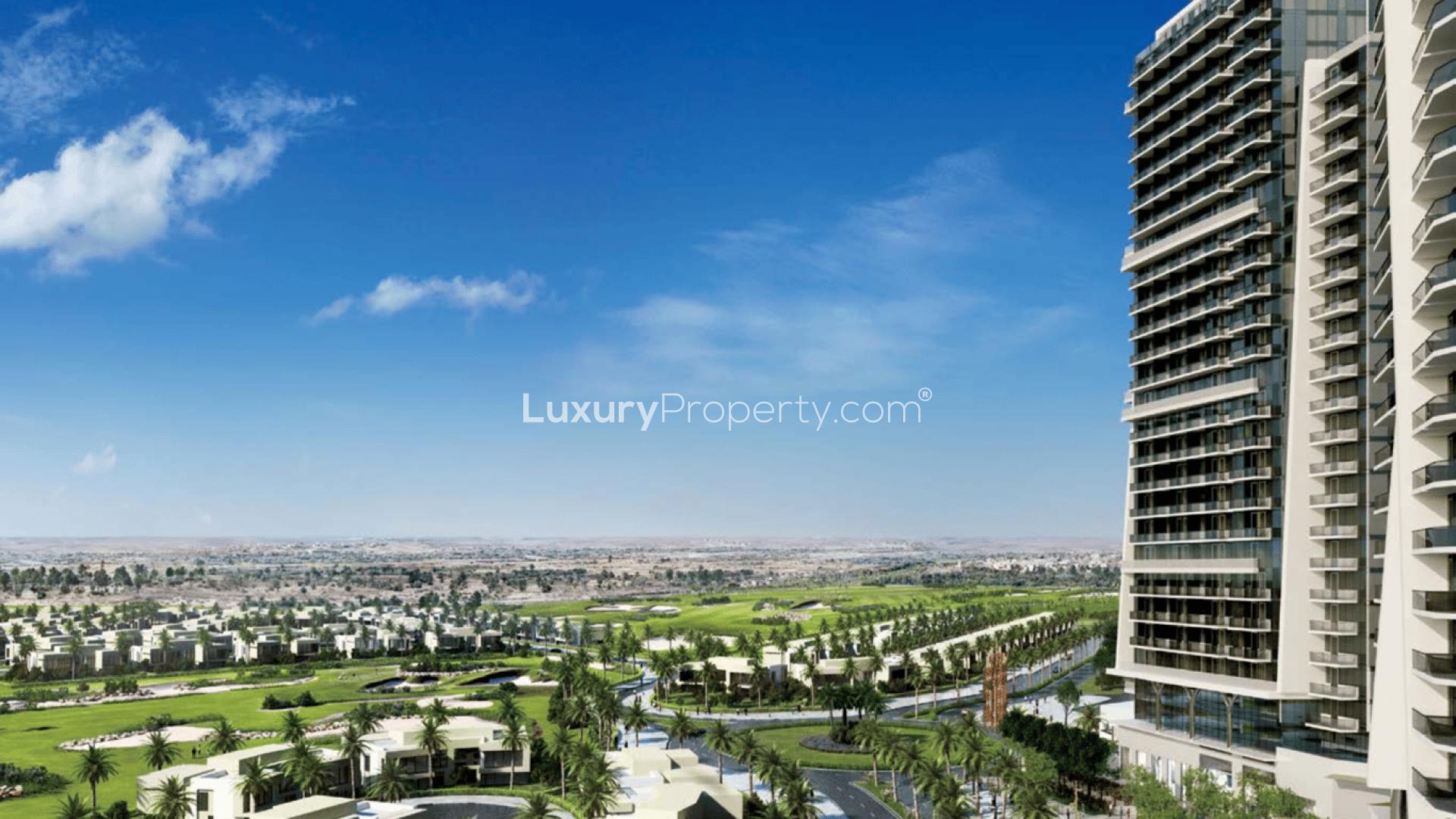 Modern high-rise apartment buildings in Damac Hills, Artesia community, with clear blue sky backdrop