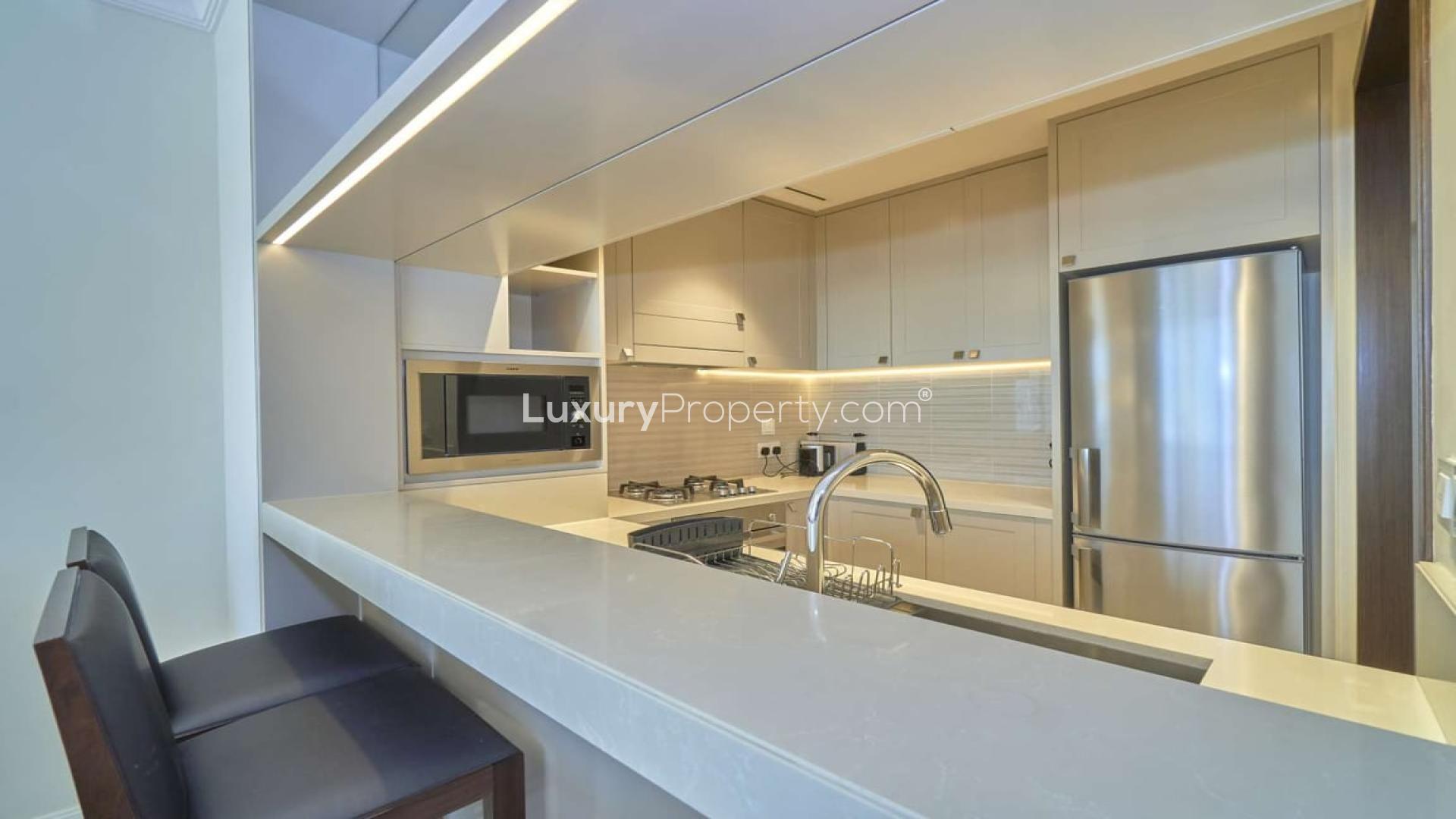 Modern kitchen in brand new Downtown Dubai apartment, featuring sleek countertops and stainless steel appliances