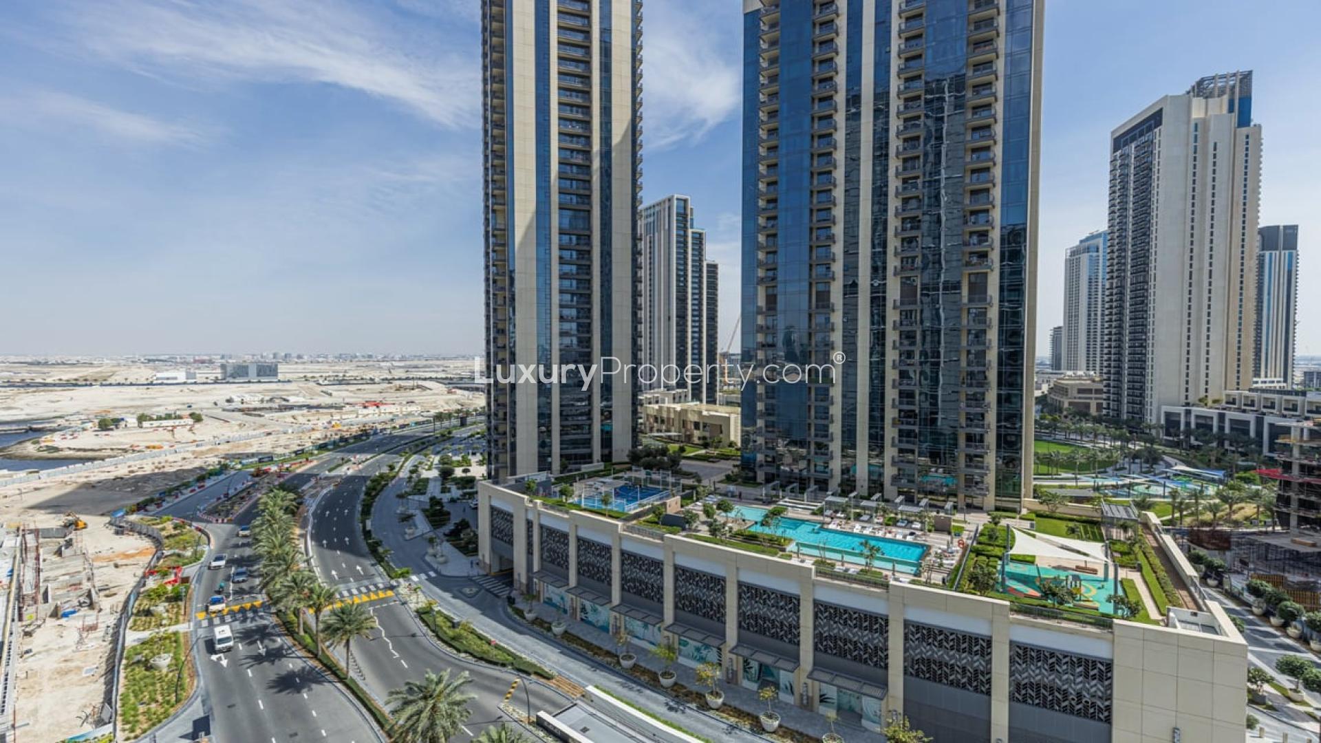 Alt text: "View of Dubai Creek Harbour skyline from Creek Edge apartment for sale.","Modern high-rise apartments in Creek Edge, Dubai Creek Harbour with pool and landscaped areas.",Modern living room in brand new waterfront apartment, Dubai Creek Harbour, Creek Edge