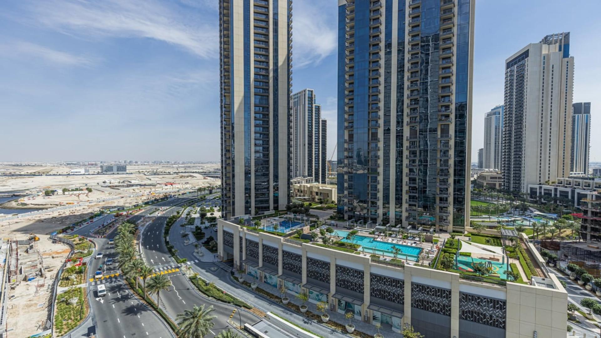 Alt text: "View of Dubai Creek Harbour skyline from Creek Edge apartment for sale.","Modern high-rise apartments in Creek Edge, Dubai Creek Harbour with pool and landscaped areas.",Modern living room in brand new waterfront apartment, Dubai Creek Harbour, Creek Edge