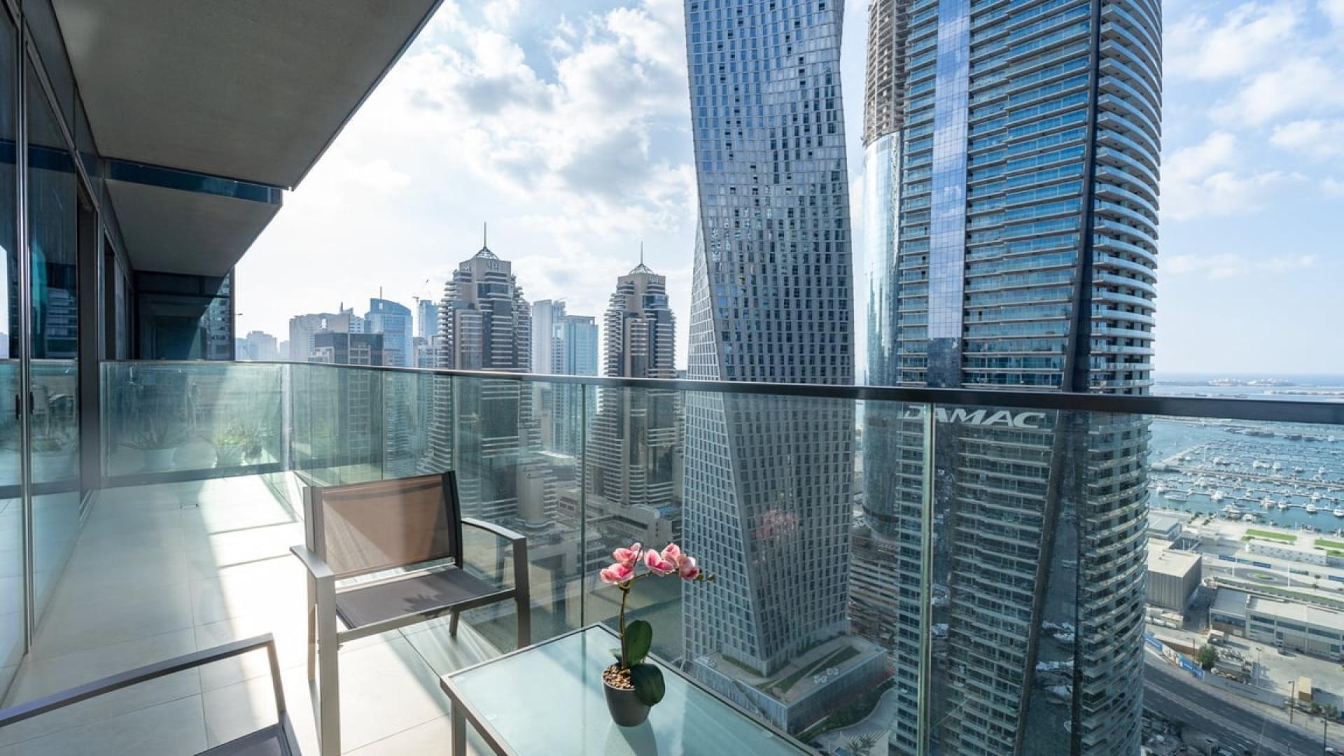 Modern living room in Marina Gate apartment with balcony and stunning Dubai Marina views