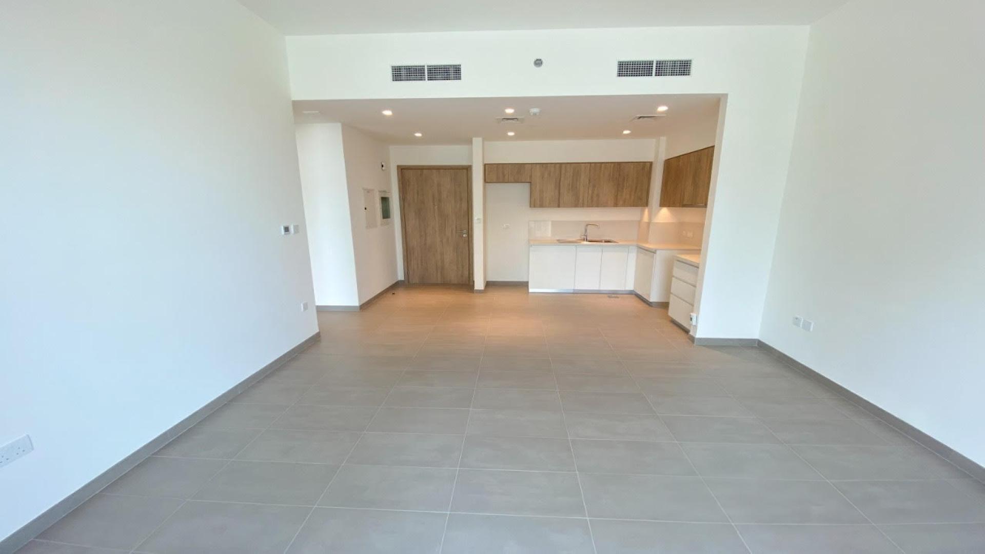 Bright living room with large window in Dubai Hills Estate apartment, Executive Residences