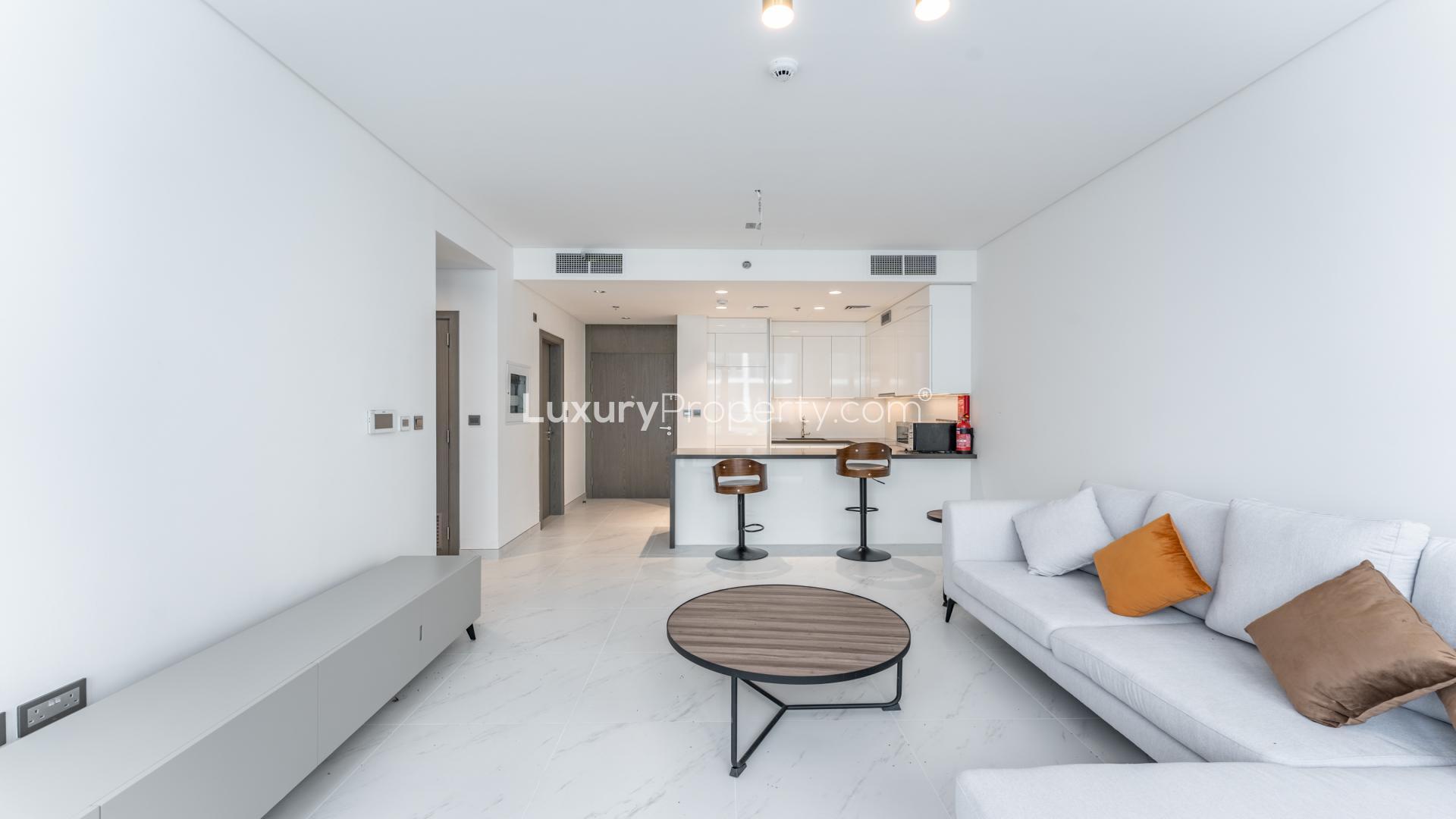 Furnished apartment living area with modern decor, open kitchen in District One, MBR City